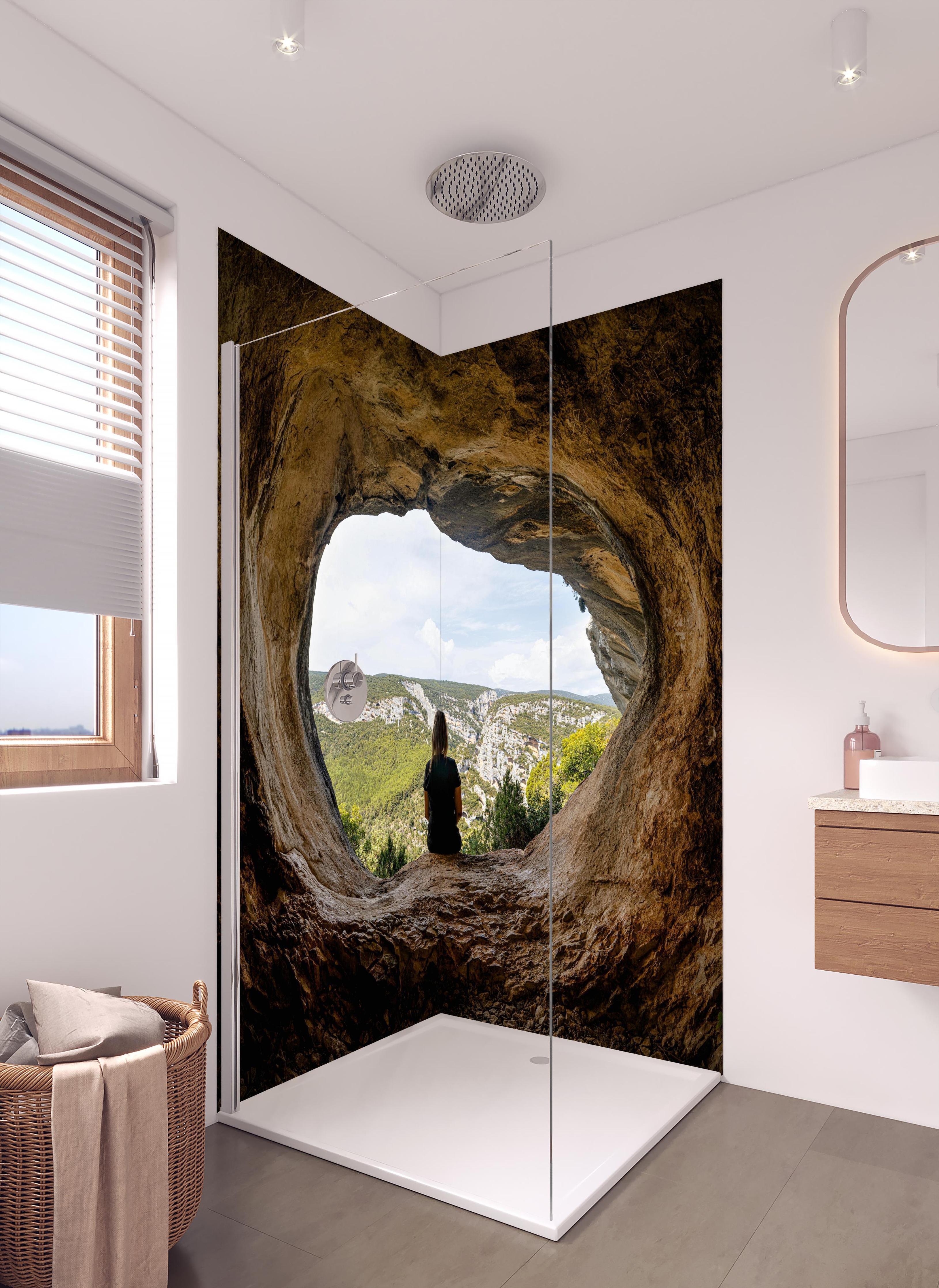 Duschrückwand - Frau sitzend in Berghöhle mit Blick auf Landschaft in hellem Badezimmer mit Regenduschkopf  - zweiteilige Eck-Duschrückwand