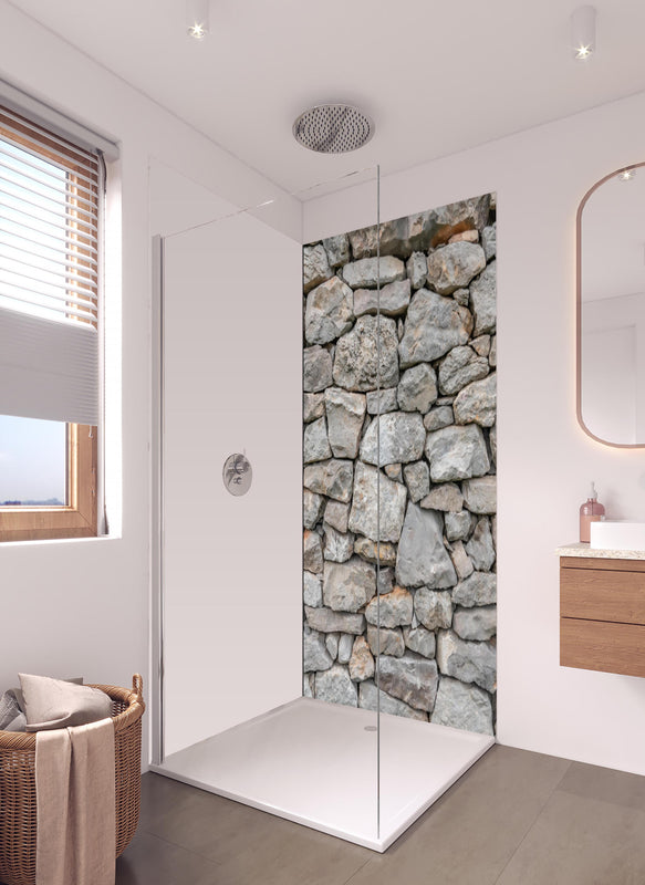 Duschrückwand - Massive raue Steinwand in hellem Badezimmer mit Regenduschkopf - einteilige Duschrückwand