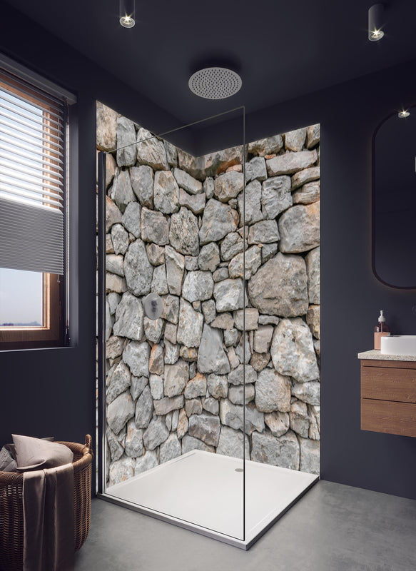 Duschrückwand - Massive raue Steinwand in dunklem Badezimmer mit Regenduschkopf
