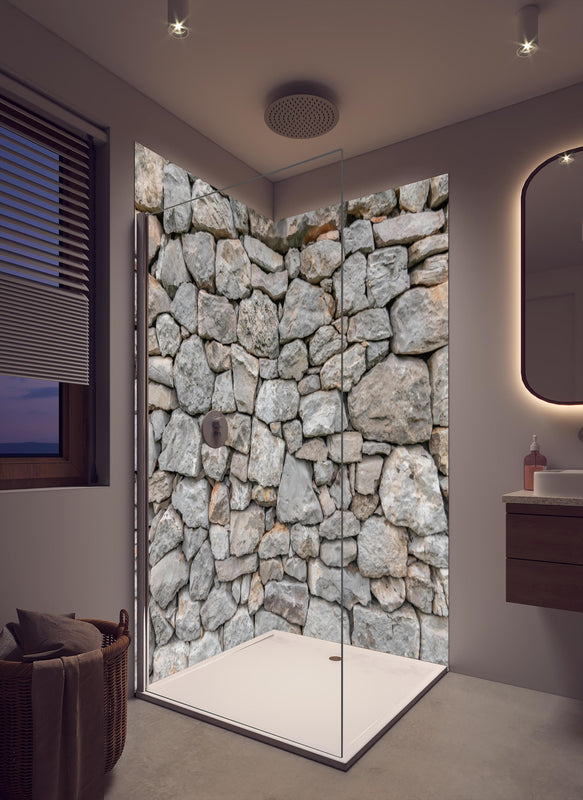Duschrückwand - Massive raue Steinwand in cremefarbenem Badezimmer mit Regenduschkopf