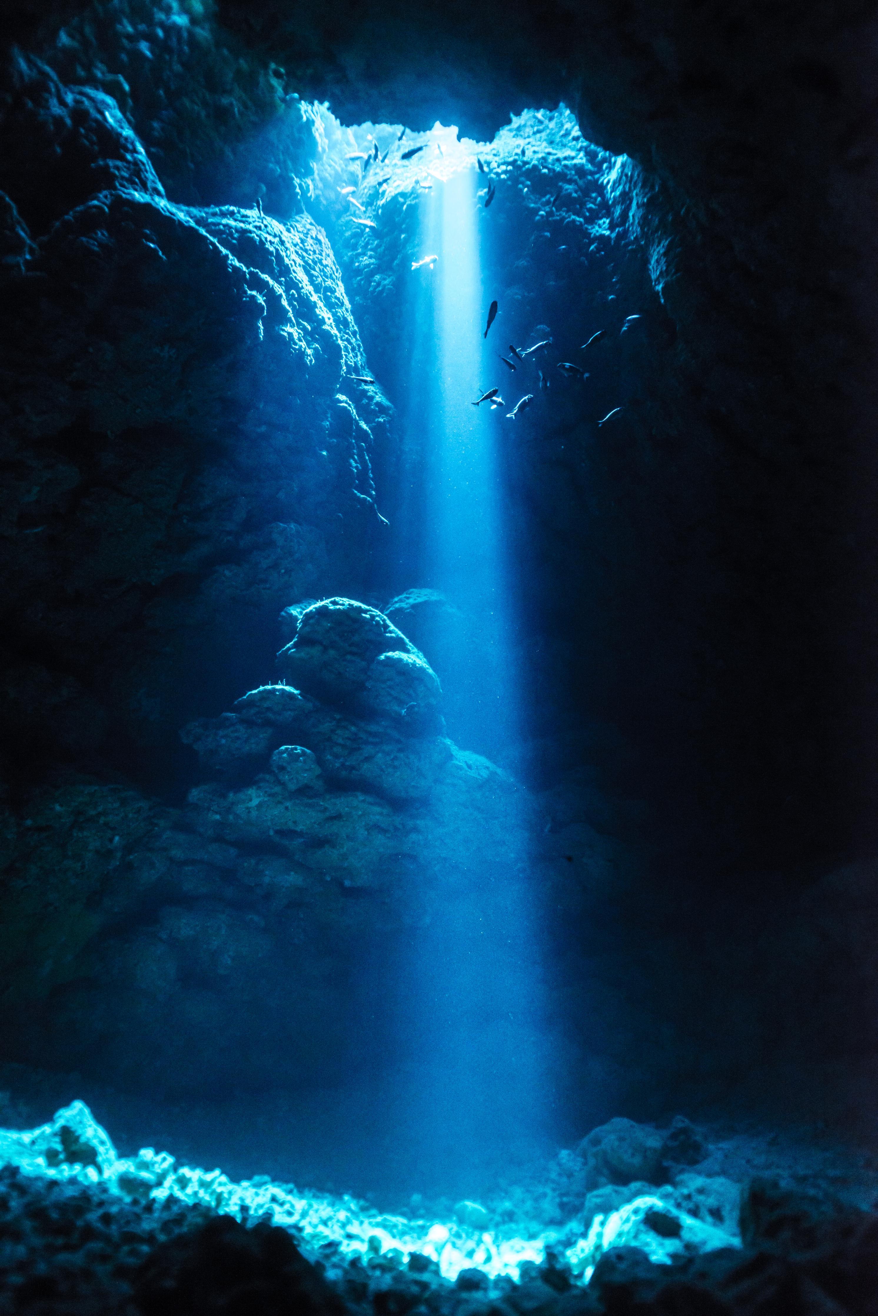 Duschrückwand-Sonnenstrahl in die Unterwasserhöhle im japanischen Ozean