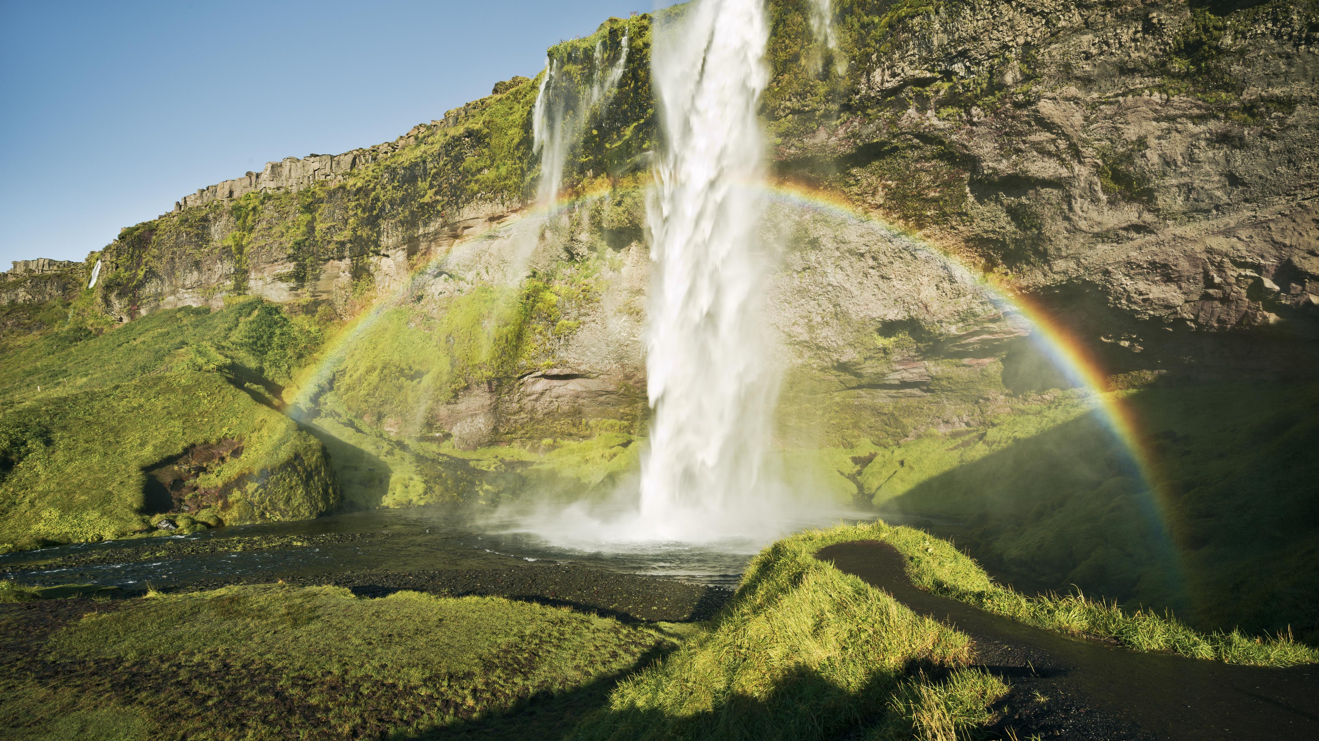 Duschrückwand-Majestätischer Wasserfall mit Regenbogen in Island