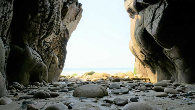 Duschrückwand - Steinstrand zwischen Felsen an Küste