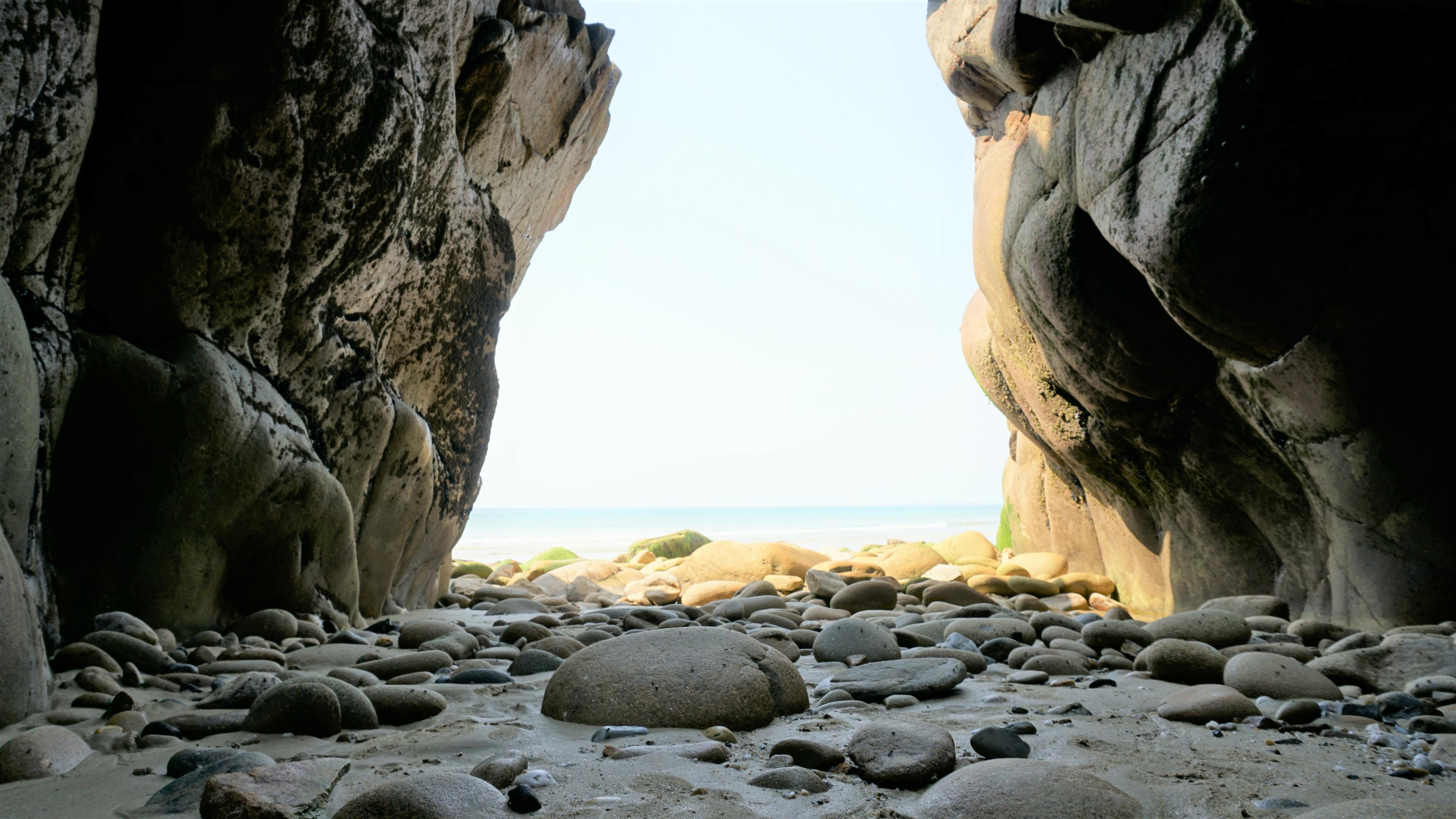 Duschrückwand-Steinstrand zwischen Felsen an Küste 