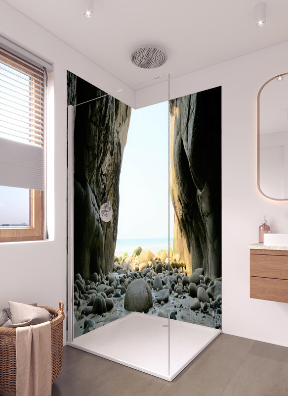 Duschrückwand - Steinstrand zwischen Felsen an Küste  in hellem Badezimmer mit Regenduschkopf  - zweiteilige Eck-Duschrückwand