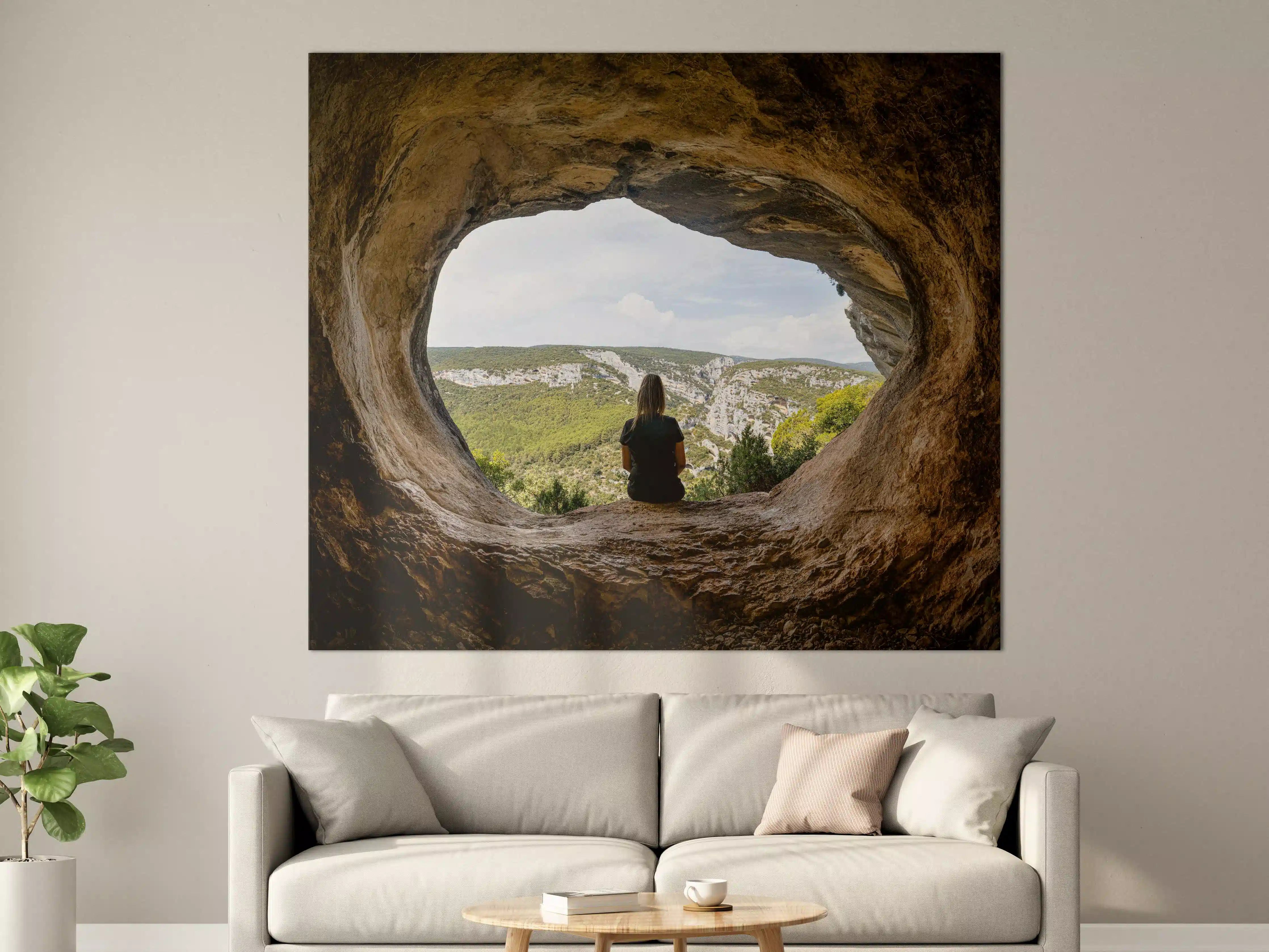 Große Wandbilder - Frau sitzend in Berghöhle mit Blick auf Landschaft