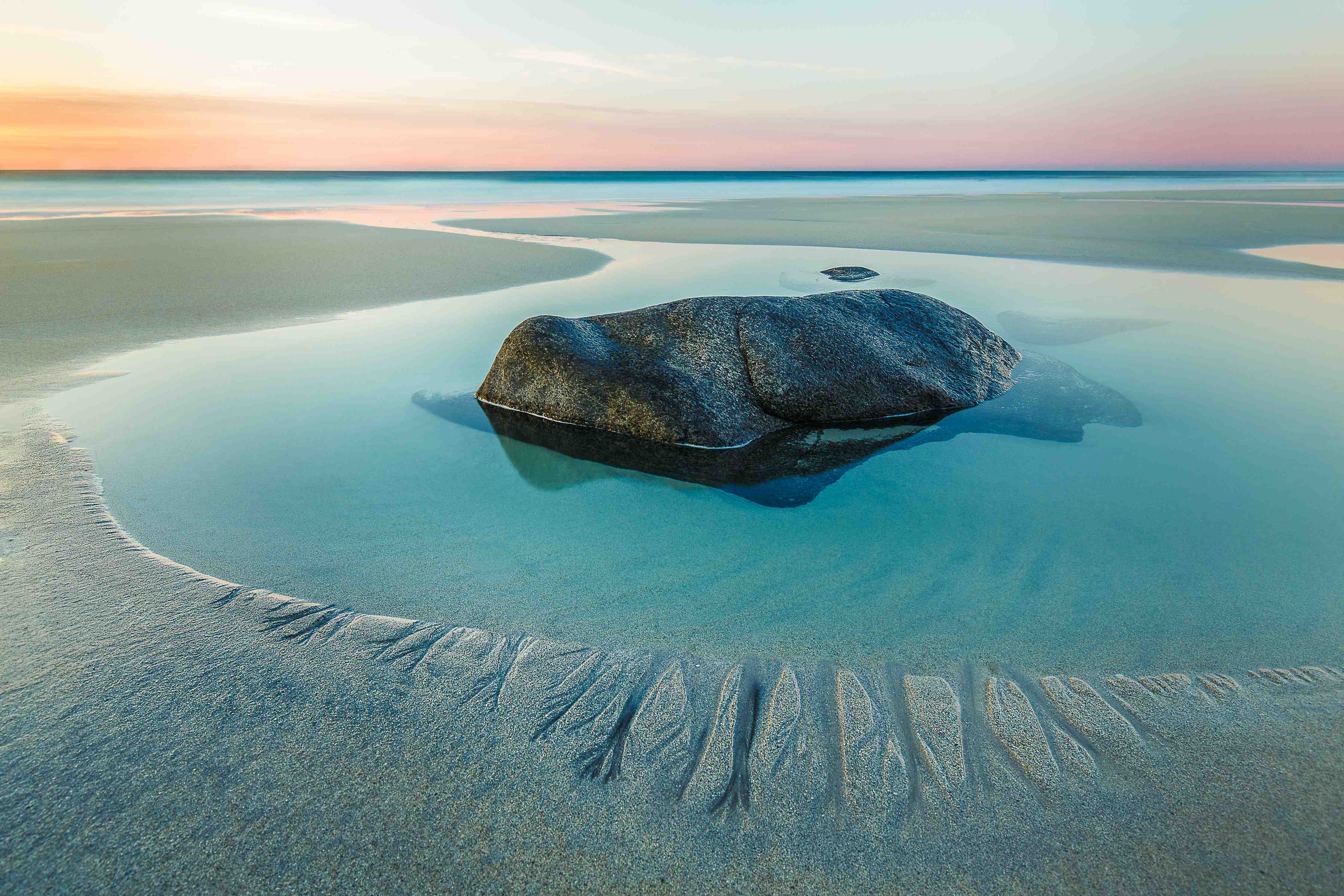 Große Wandbilder-Sanfte Küstenlandschaft mit ruhigem Wasser und Felsen am Strand