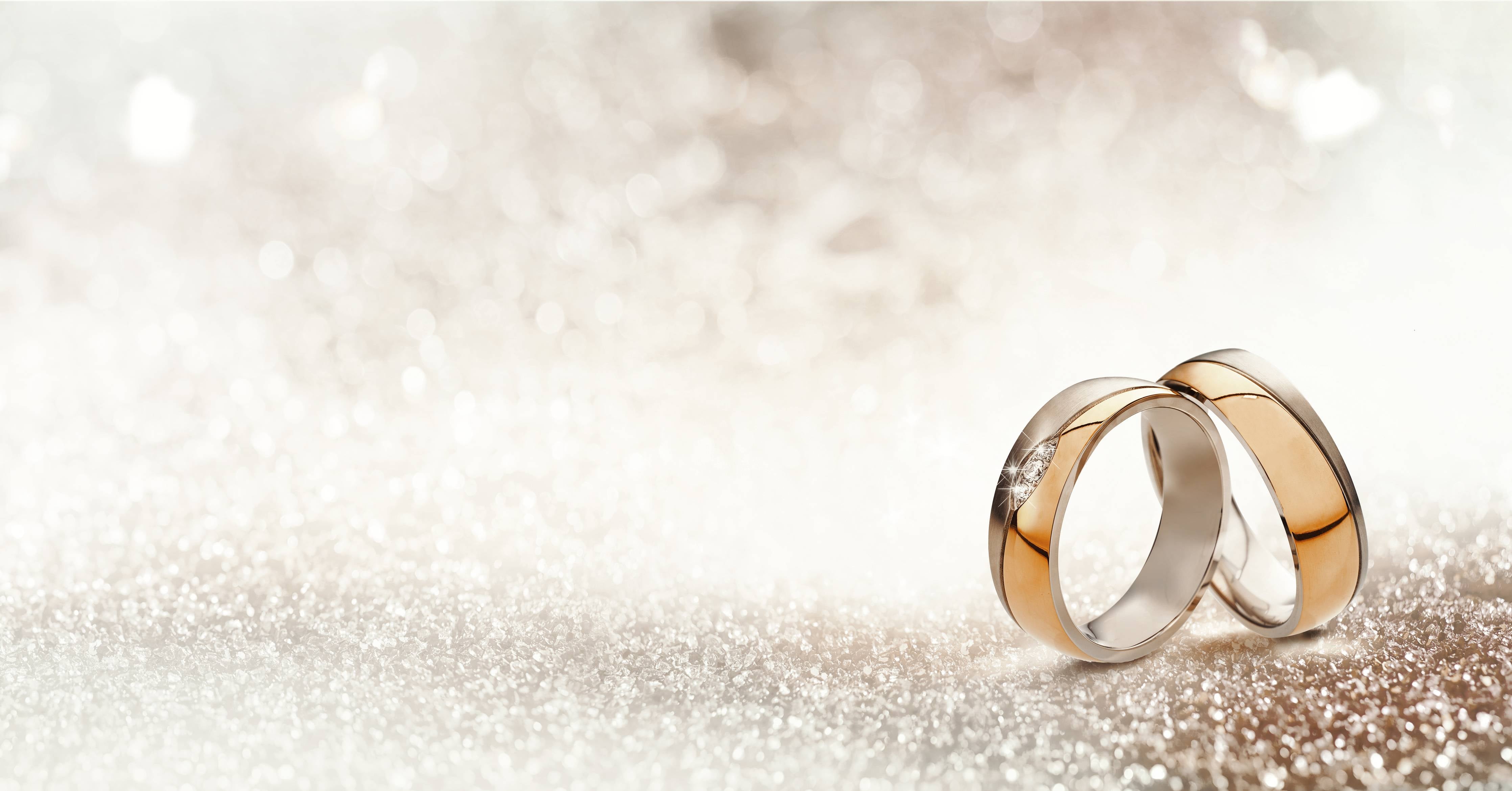 Große Wandbilder-Zwei goldene Eheringe mit Glitter Hintergrund