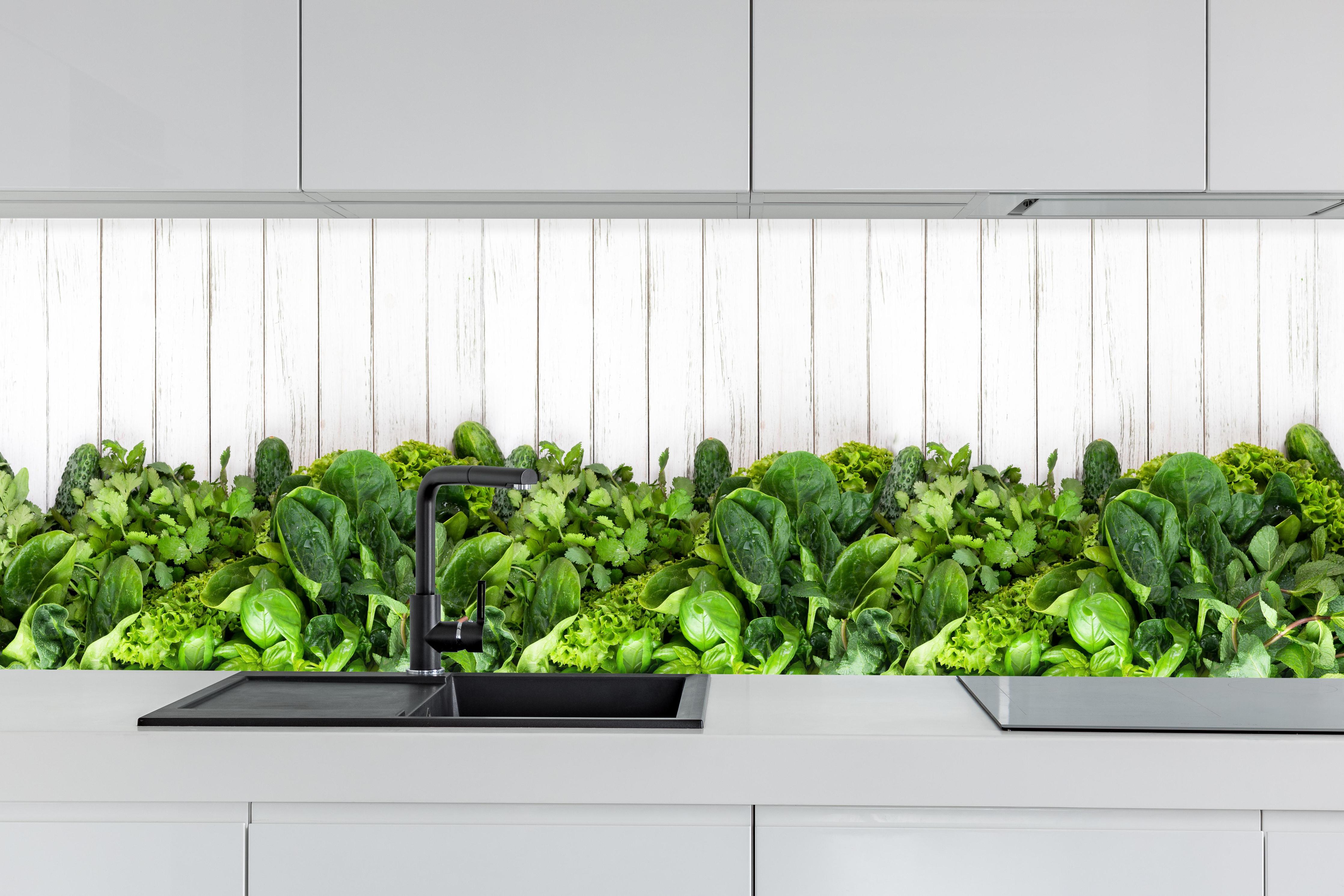 Küche - Weiß-Grün Kräuter Küchenrückwand hinter weißen Hochglanz-Küchenregalen und schwarzem Wasserhahn