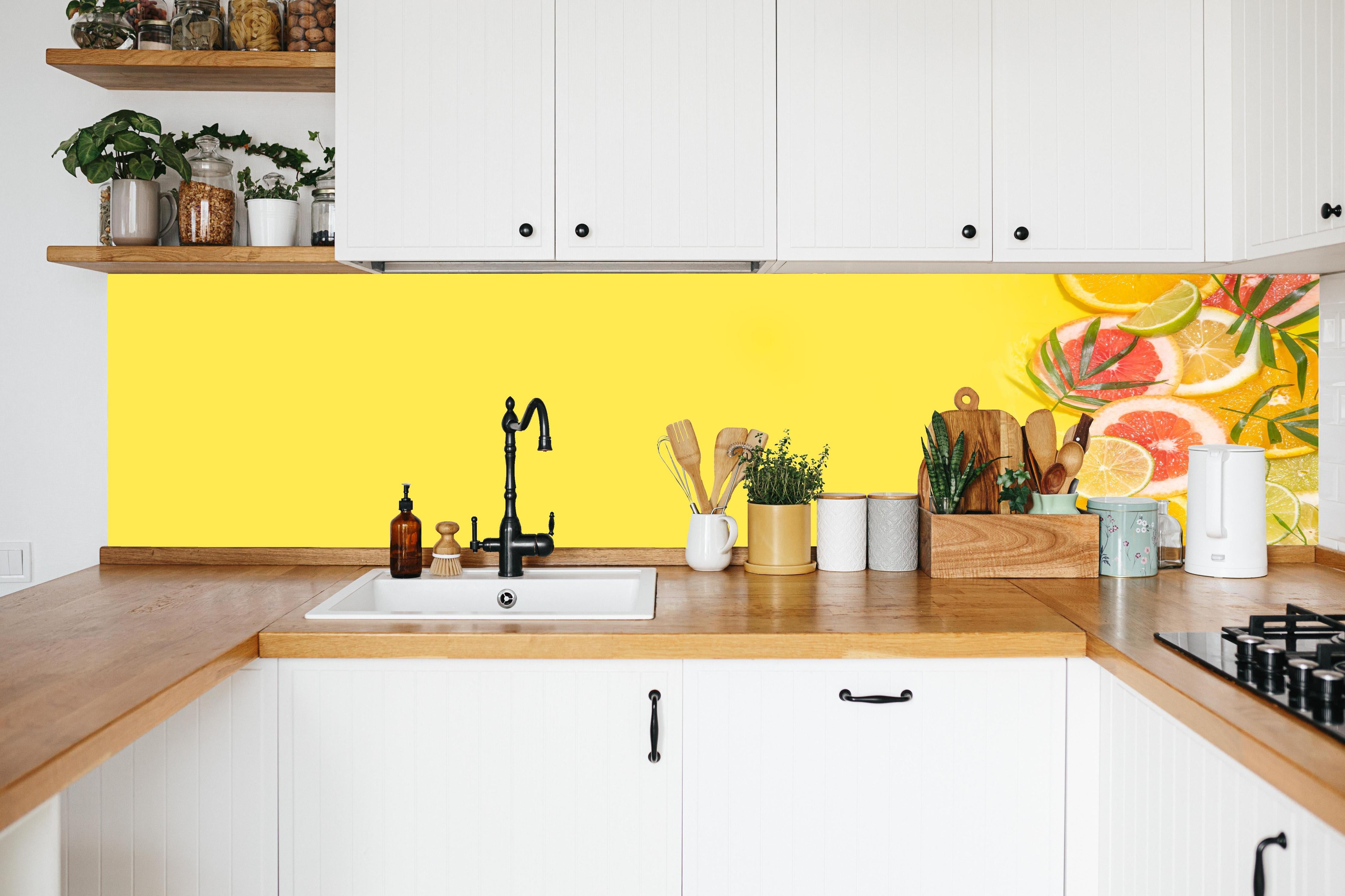 Küche - Zitrus-Küchenrückwand Gelb in weißer Küche hinter Gewürzen und Kochlöffeln aus Holz