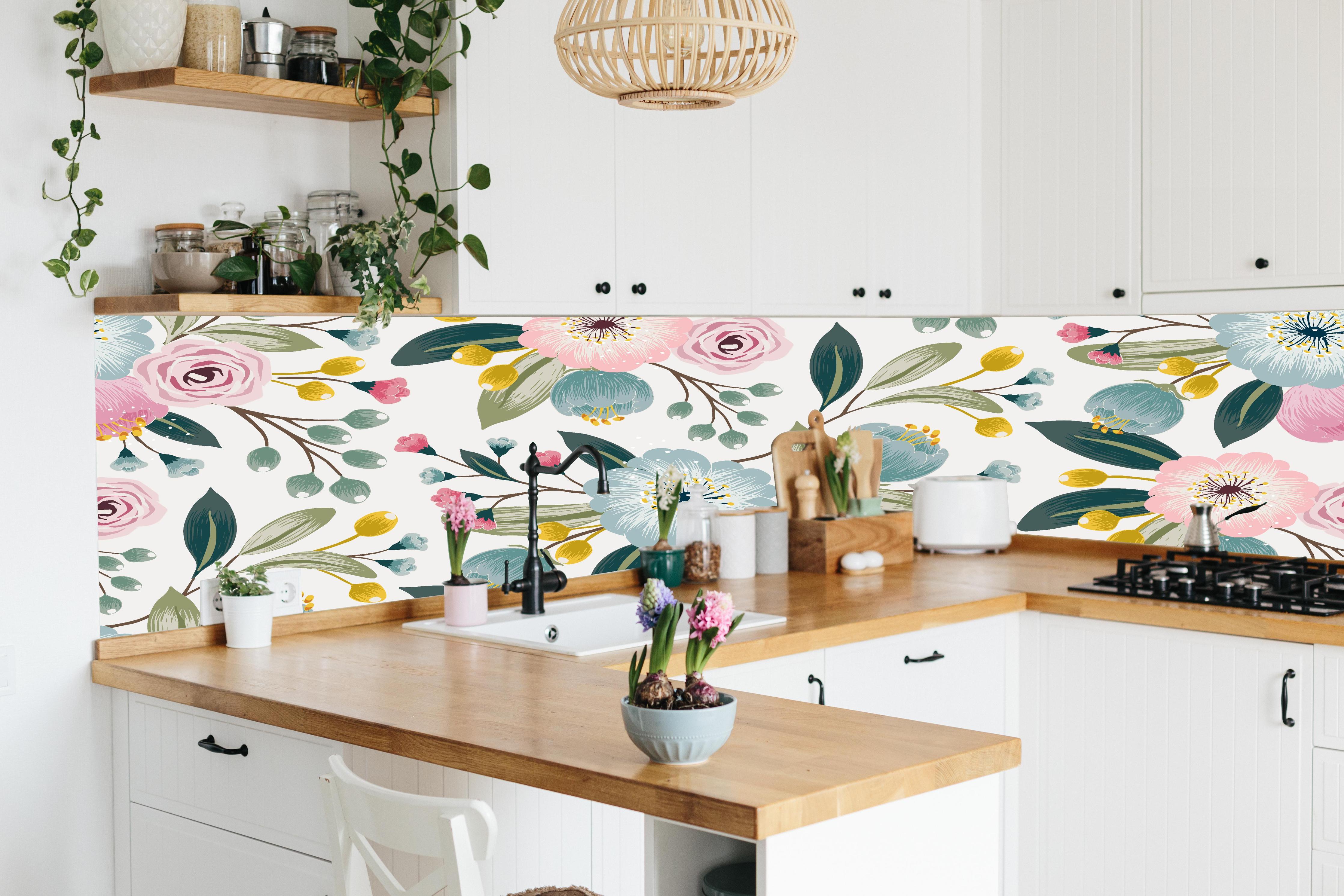 Küche - Abstrakte Blumenmuster in Rosa und Hellblau hinter weißen Hochglanz-Küchenregalen und schwarzem Wasserhahn