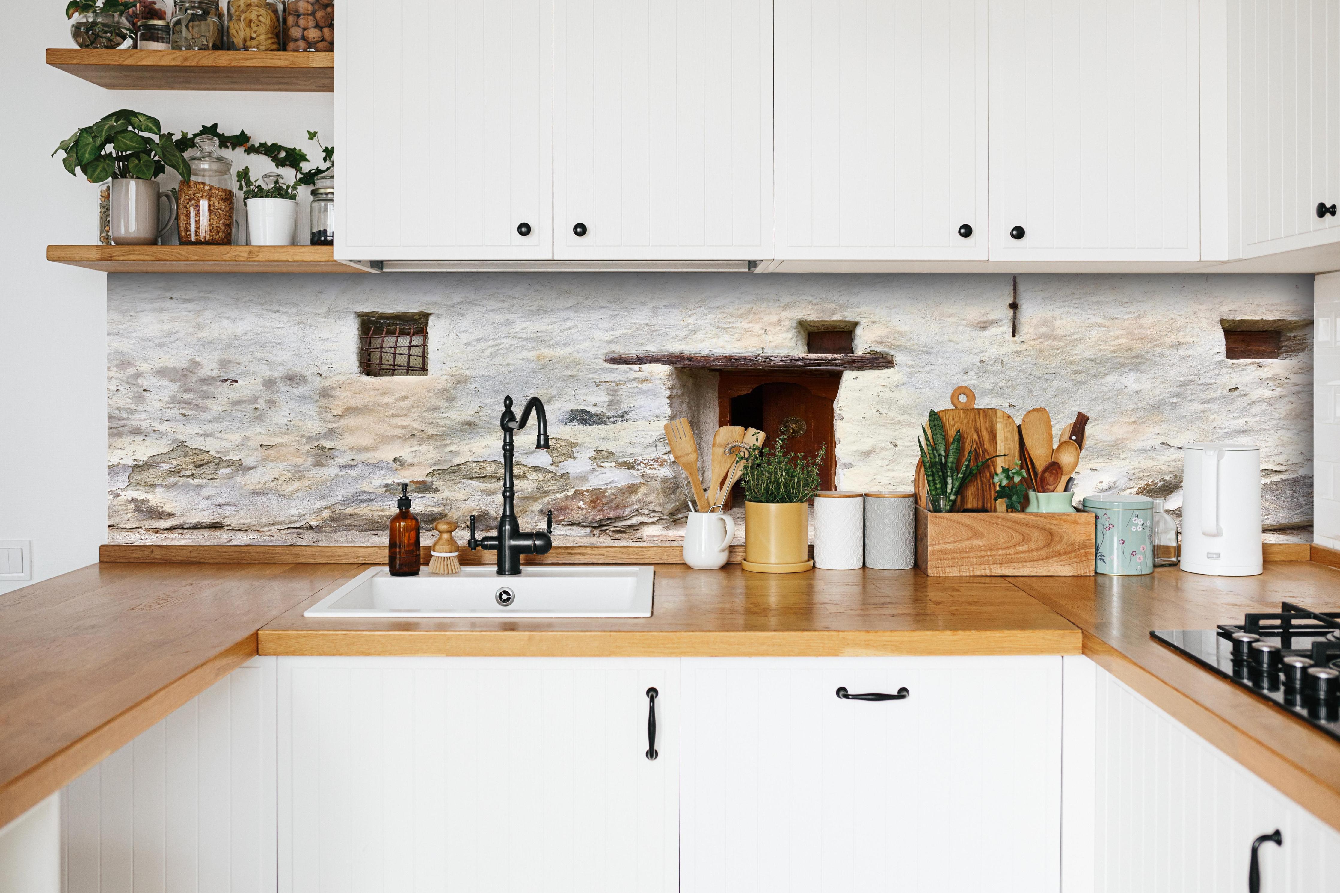 Küche - Alter Türeingang in Südtirol hinter weißen Hochglanz-Küchenregalen und schwarzem Wasserhahn