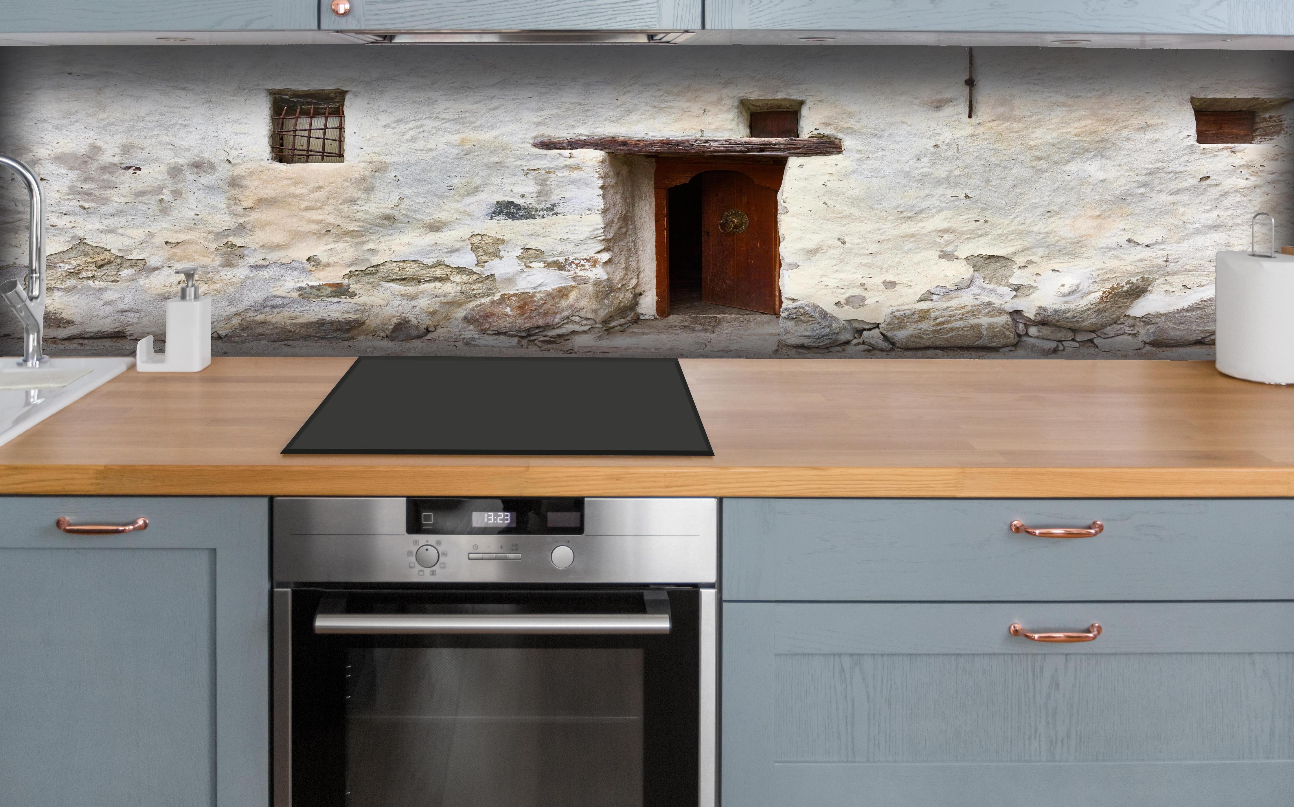 Küche - Alter Türeingang in Südtirol hinter weißen Hochglanz-Küchenregalen und schwarzem Wasserhahn