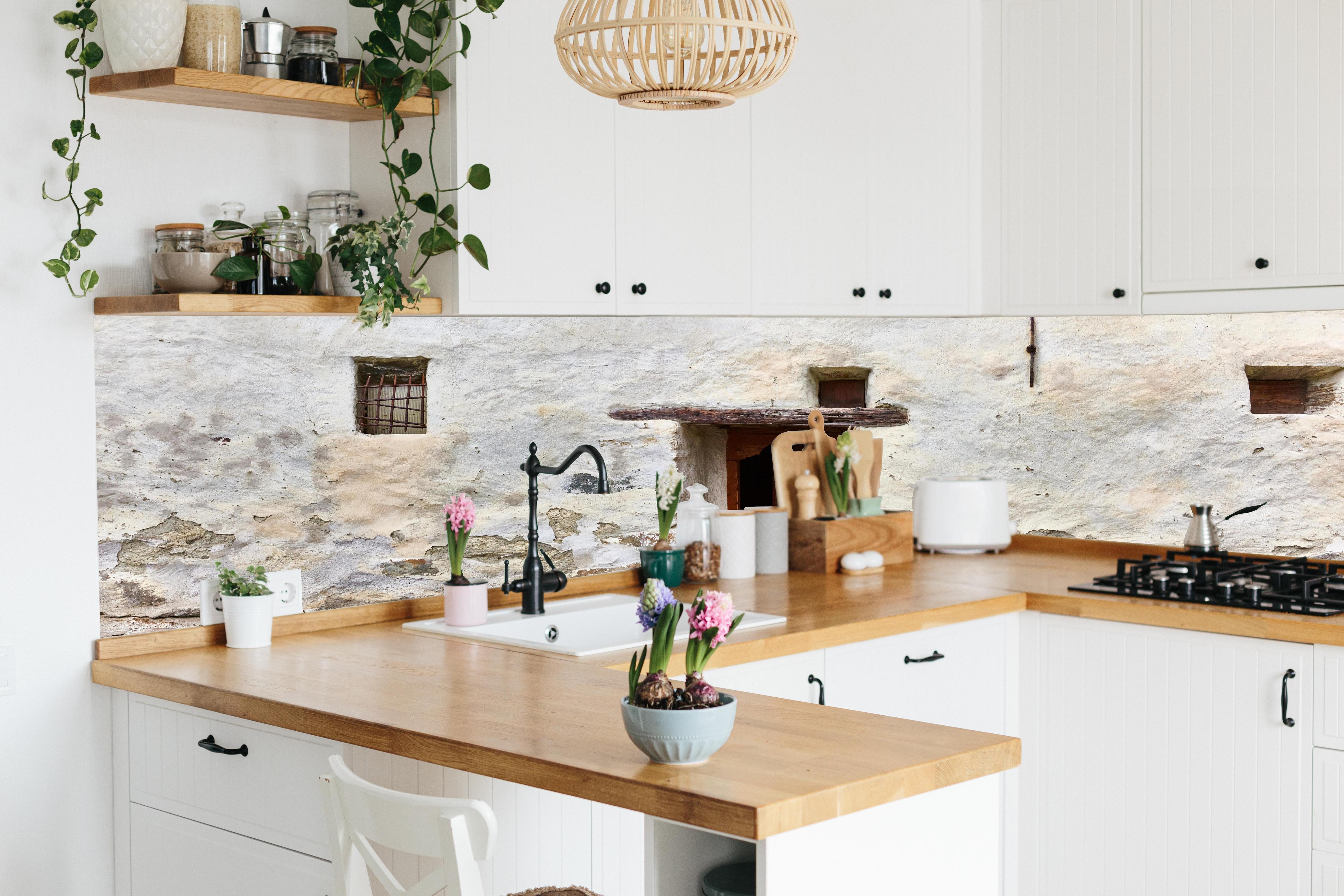 Küche - Alter Türeingang in Südtirol hinter weißen Hochglanz-Küchenregalen und schwarzem Wasserhahn