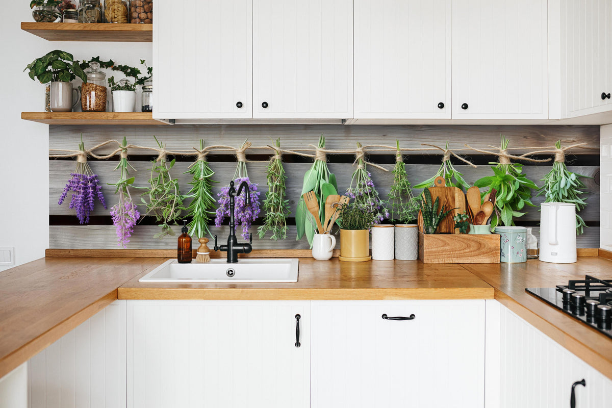 Küche - Aromatische Küchenkräuter im Panoramaformat hinter weißen Hochglanz-Küchenregalen und schwarzem Wasserhahn