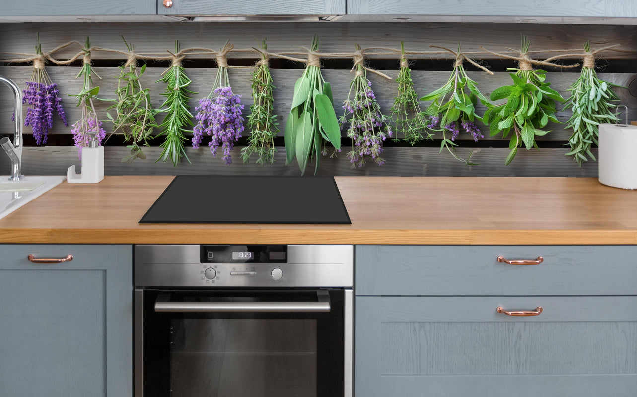 Küche - Aromatische Küchenkräuter im Panoramaformat hinter weißen Hochglanz-Küchenregalen und schwarzem Wasserhahn