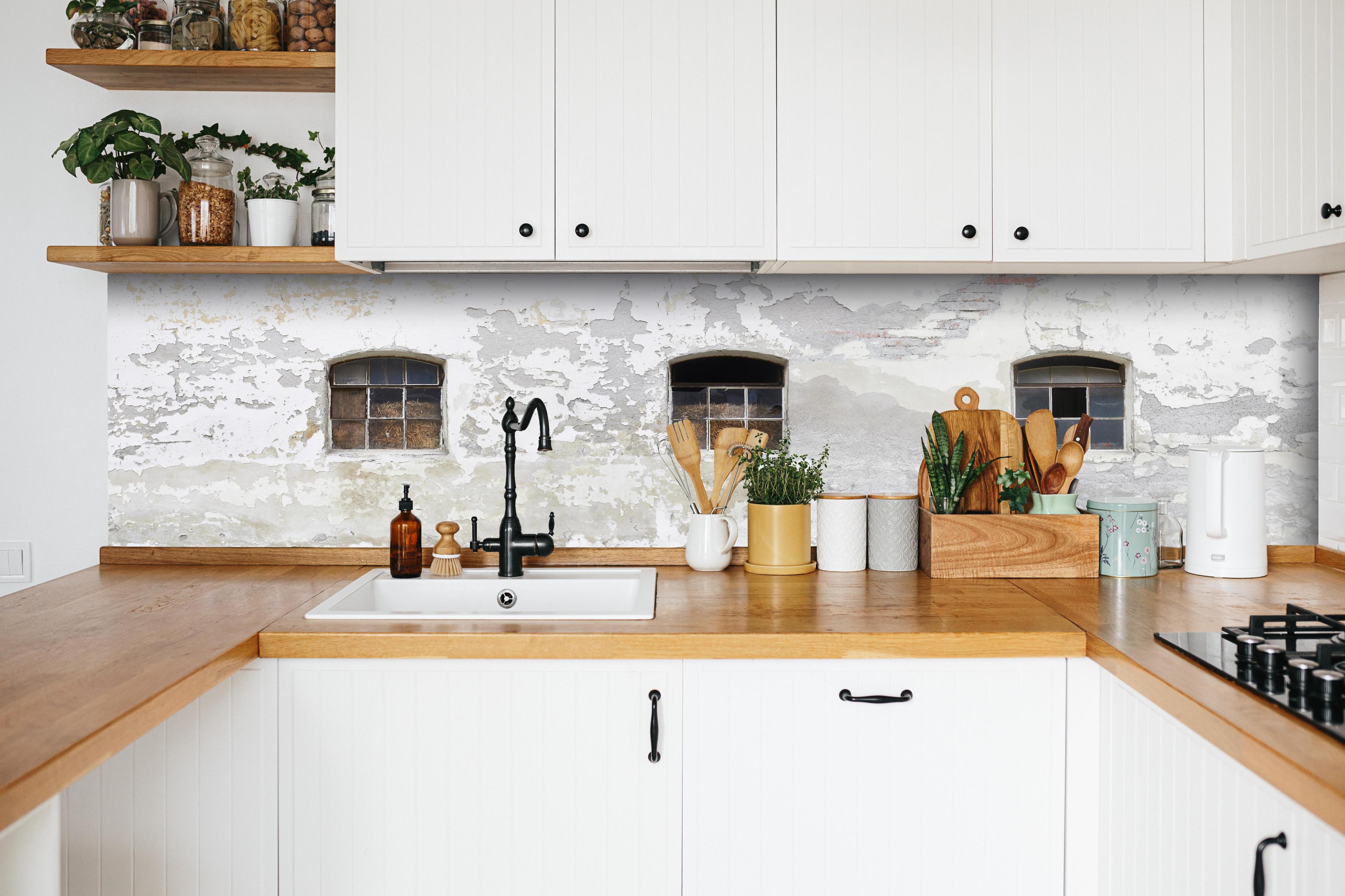 Küche - Beschädigte Fenster einer veralteten Hauswand hinter weißen Hochglanz-Küchenregalen und schwarzem Wasserhahn