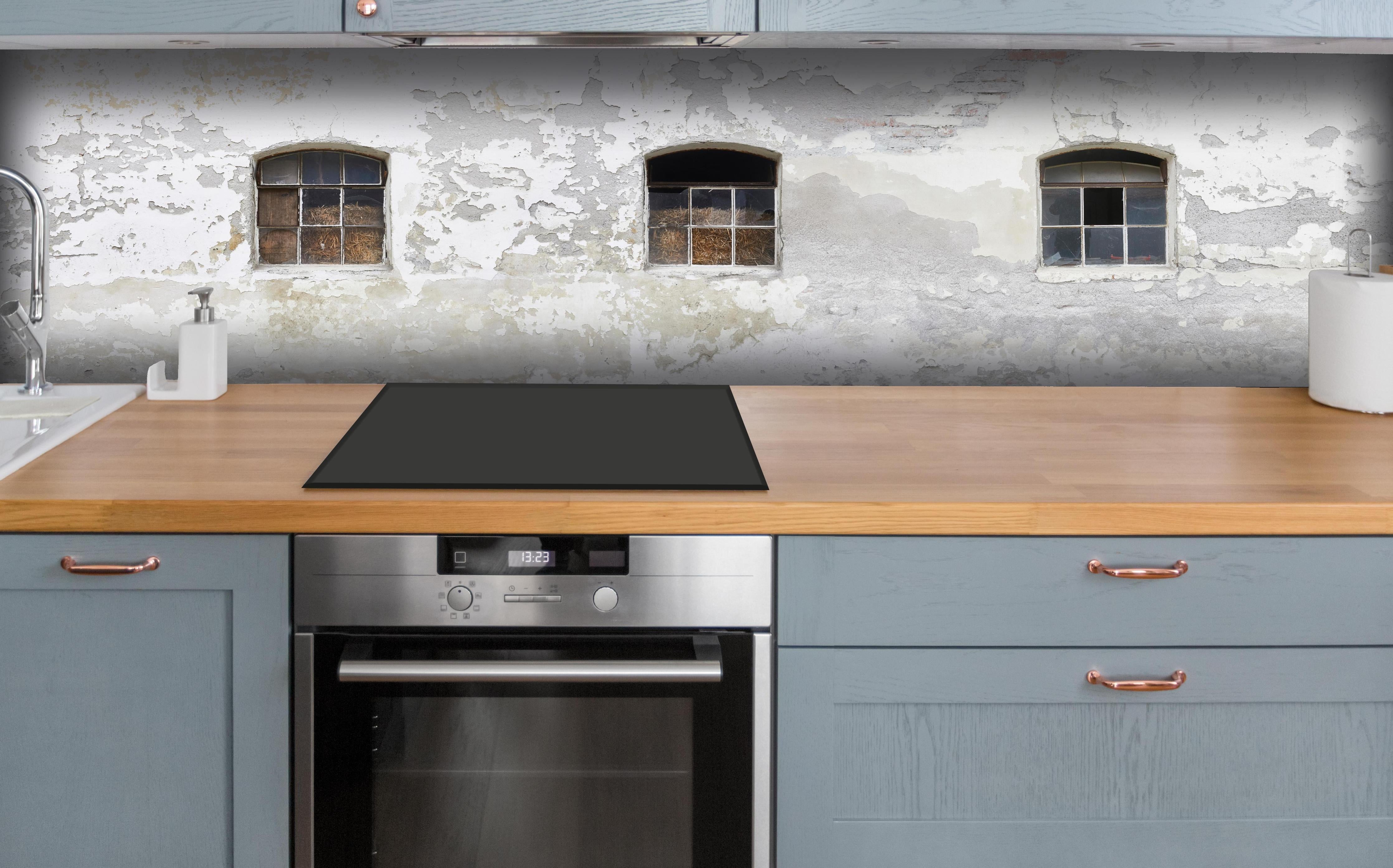 Küche - Beschädigte Fenster einer veralteten Hauswand hinter weißen Hochglanz-Küchenregalen und schwarzem Wasserhahn