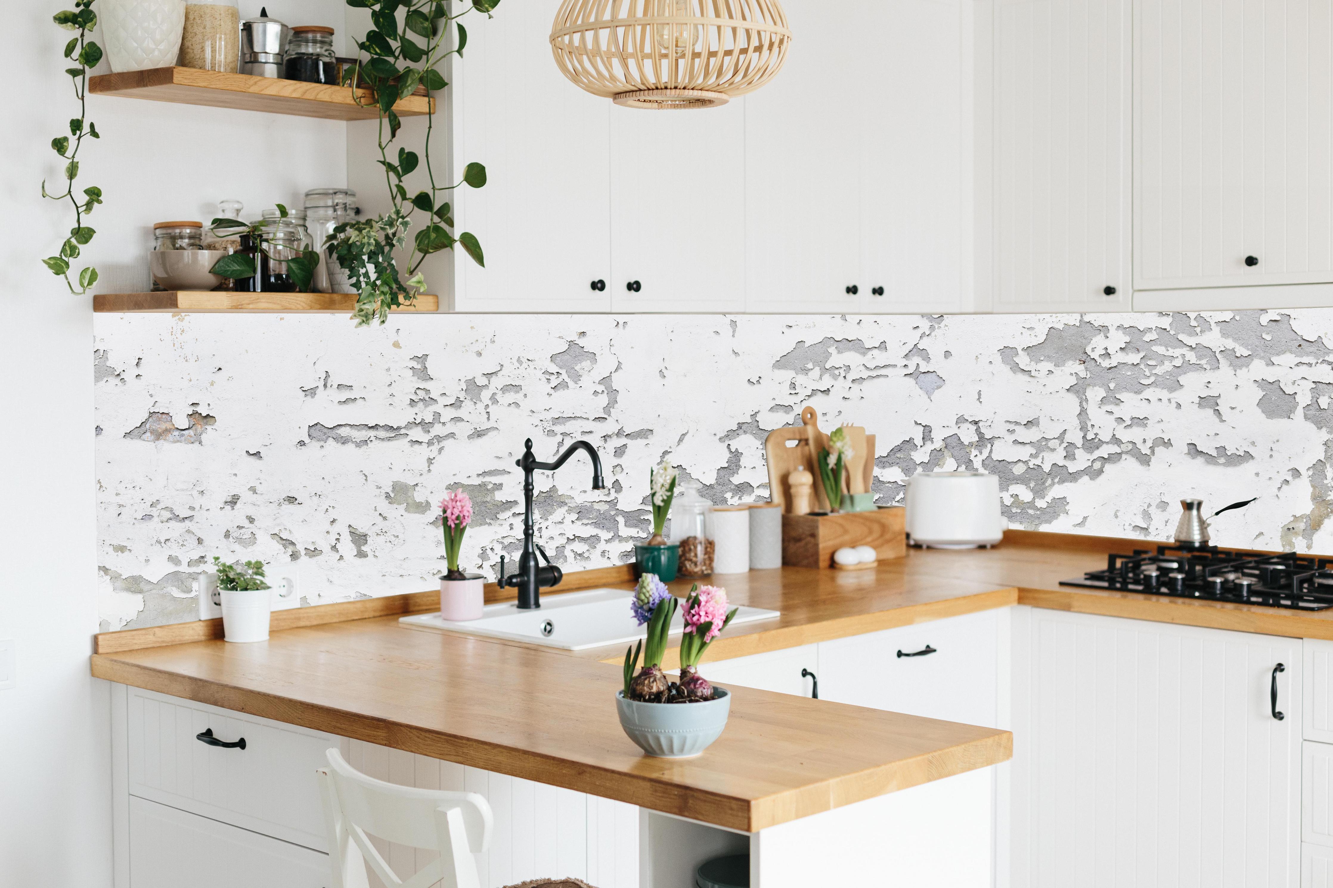 Küche - Beschädigte Wandstruktur hinter weißen Hochglanz-Küchenregalen und schwarzem Wasserhahn