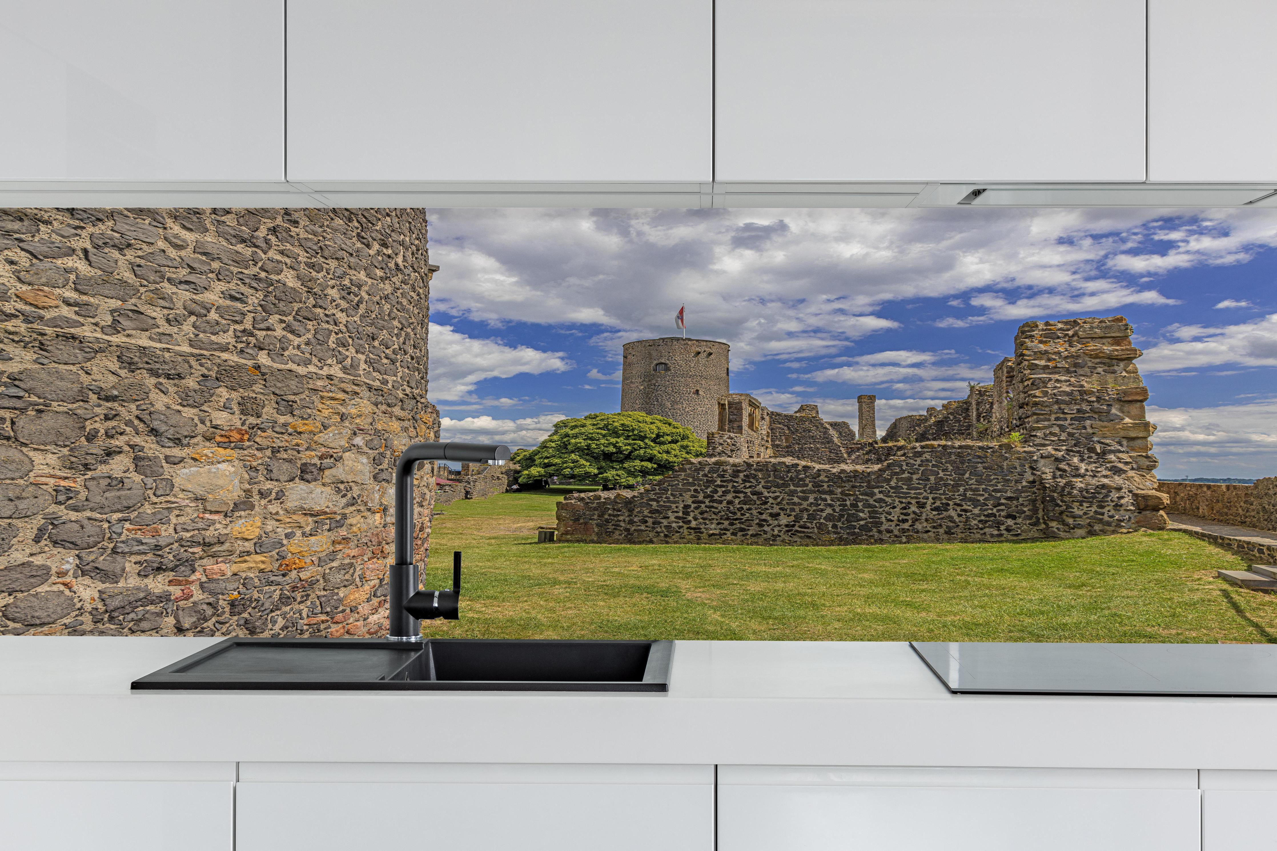 Küche - Bild von der Burgruine Münzenberg in Hessen hinter weißen Hochglanz-Küchenregalen und schwarzem Wasserhahn