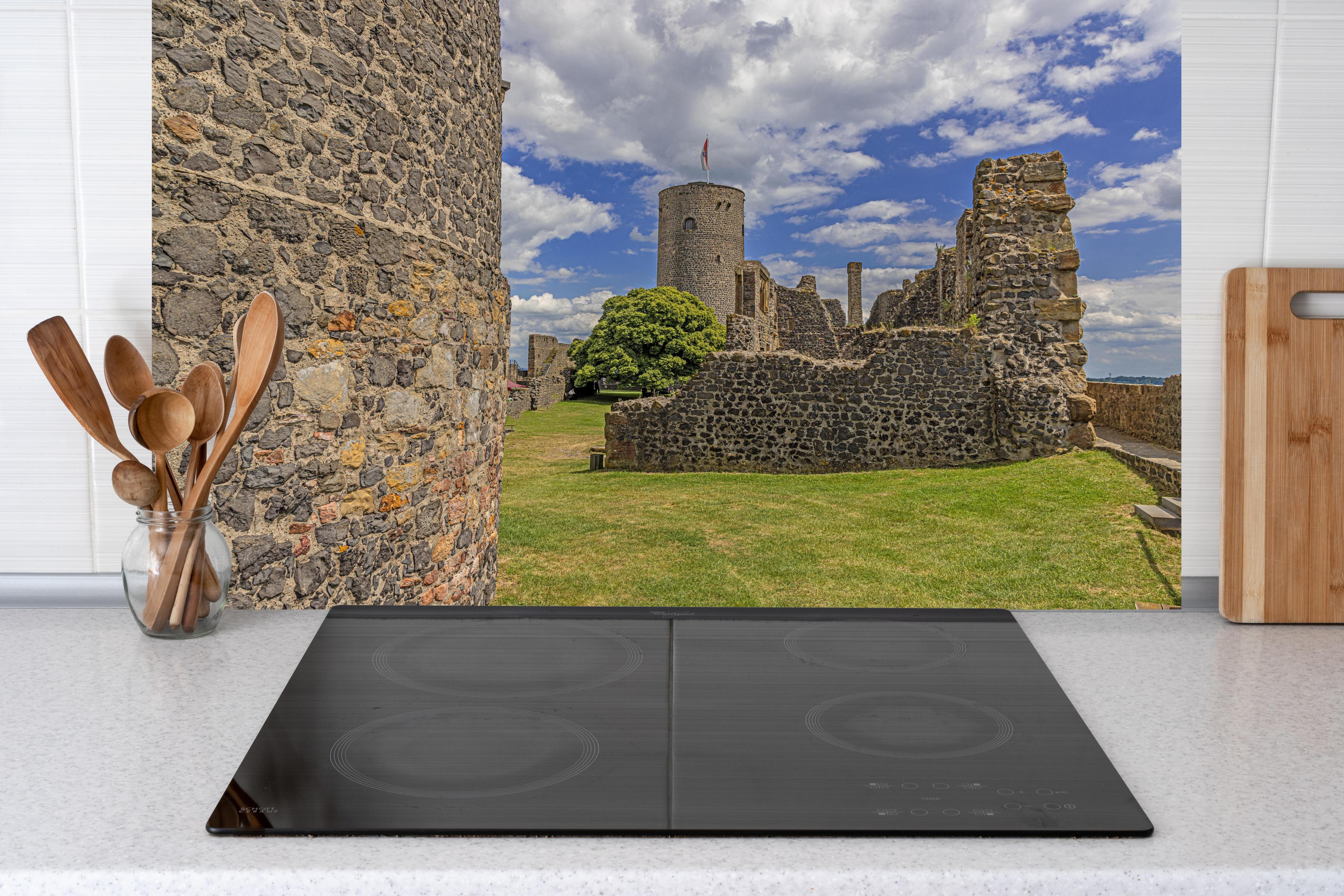 Küche - Bild von der Burgruine Münzenberg in Hessen hinter weißen Hochglanz-Küchenregalen und schwarzem Wasserhahn