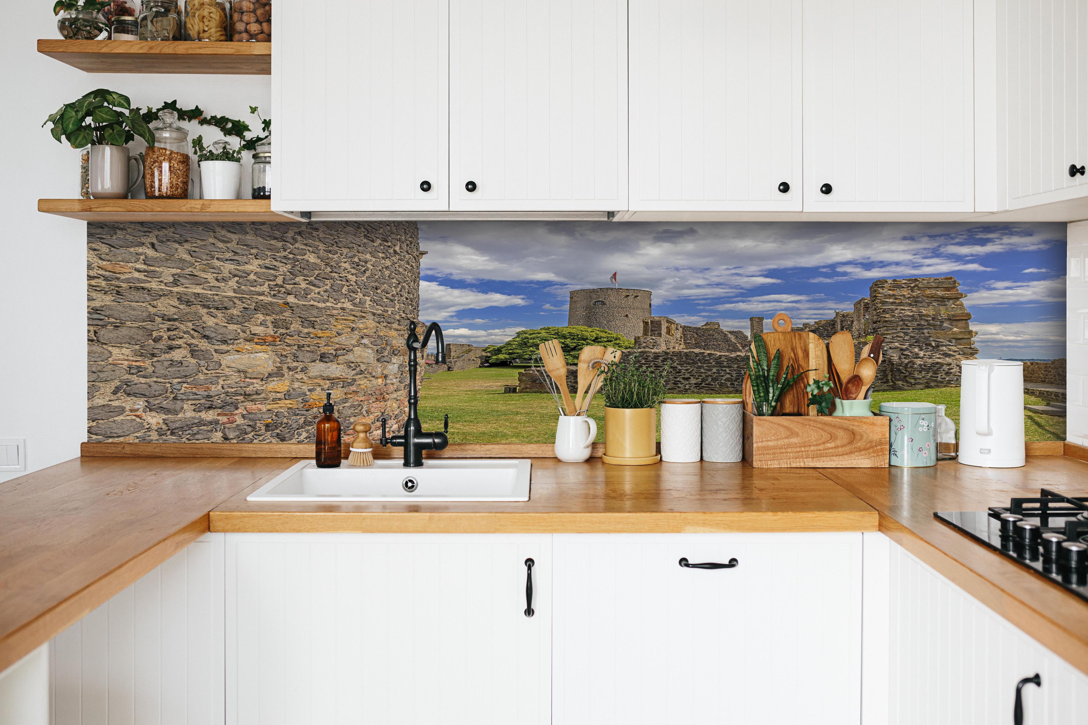 Küche - Bild von der Burgruine Münzenberg in Hessen hinter weißen Hochglanz-Küchenregalen und schwarzem Wasserhahn