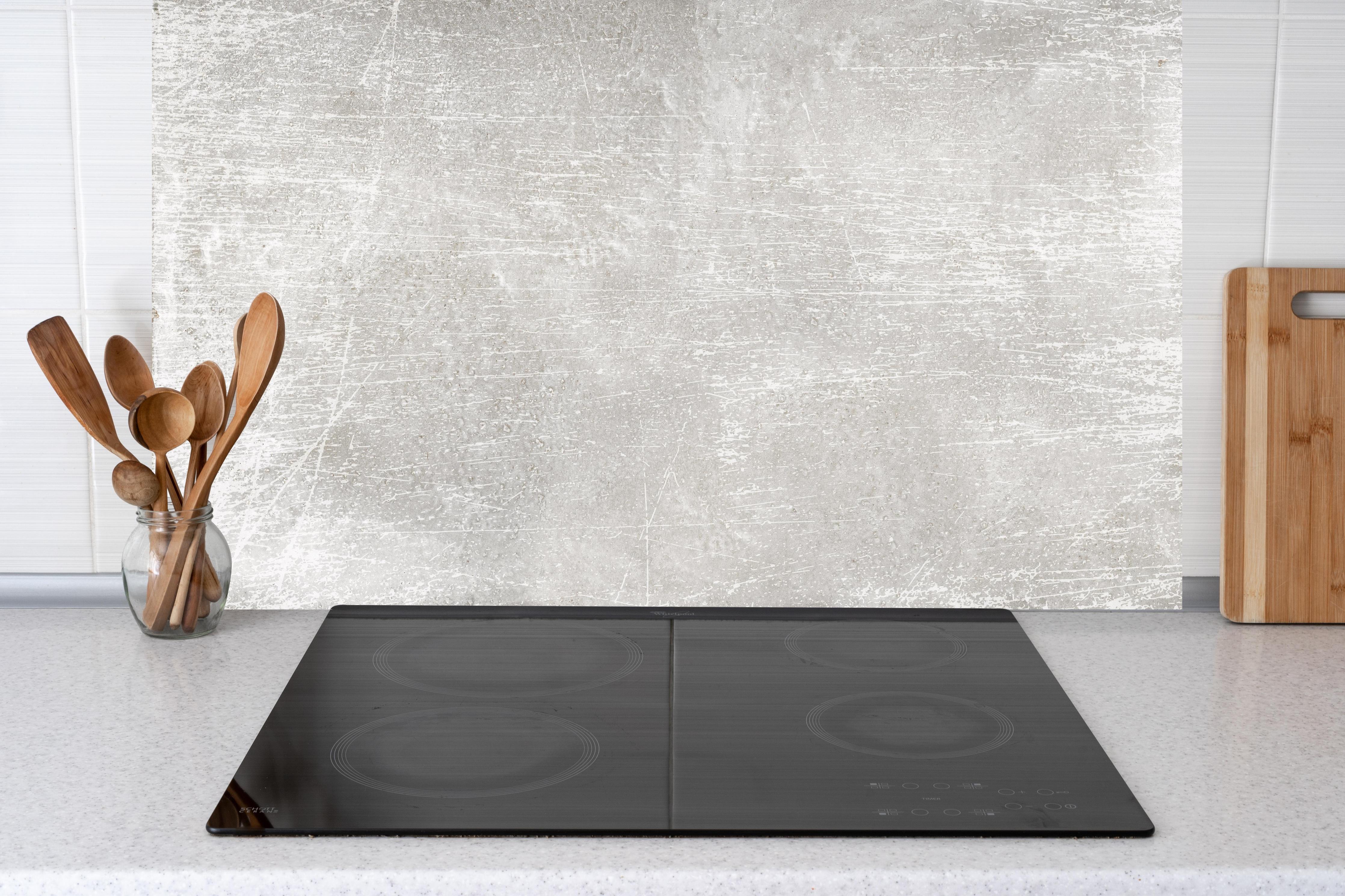 Küche - Blanker Zement Hintergrund hinter weißen Hochglanz-Küchenregalen und schwarzem Wasserhahn