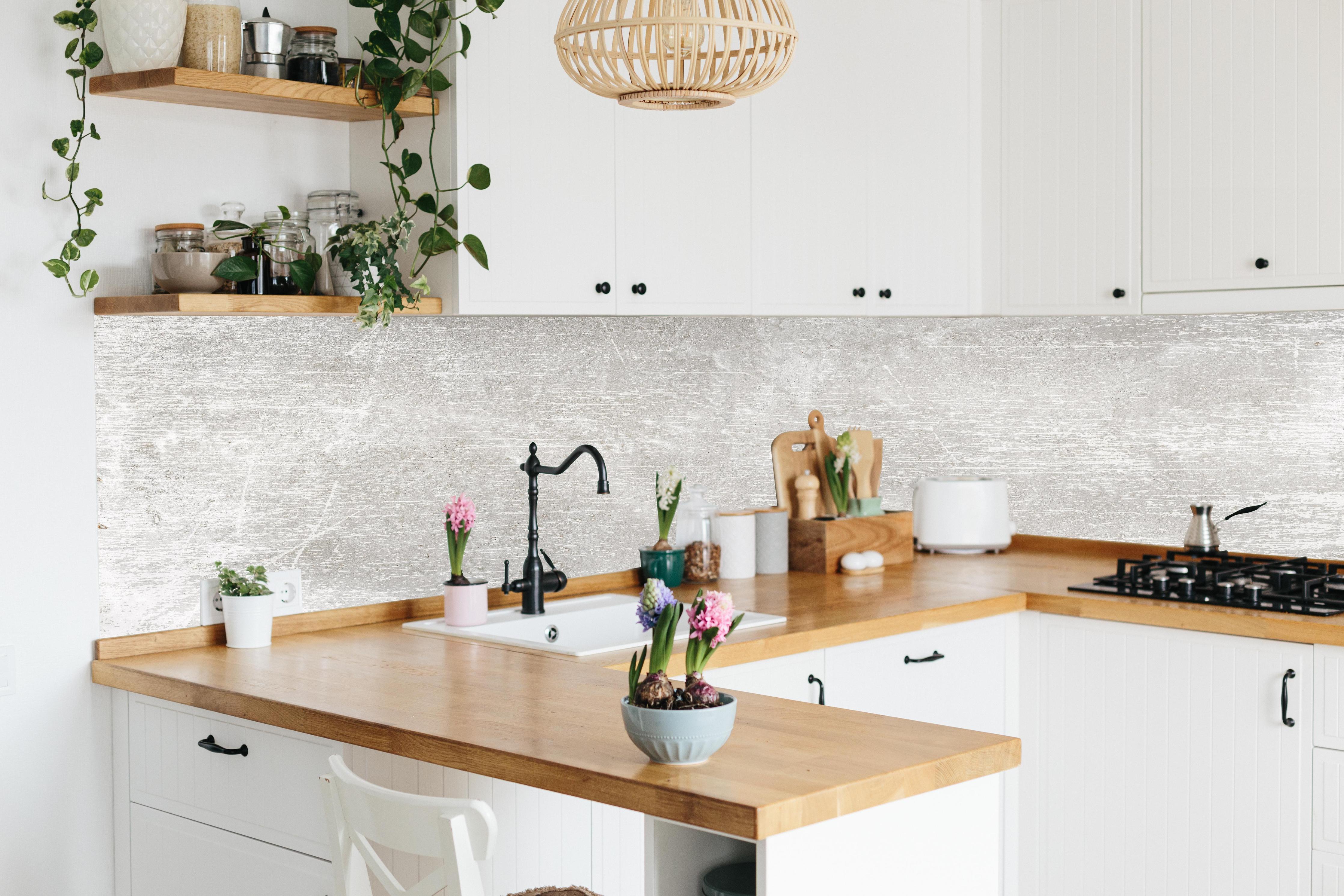 Küche - Blanker Zement Hintergrund hinter weißen Hochglanz-Küchenregalen und schwarzem Wasserhahn