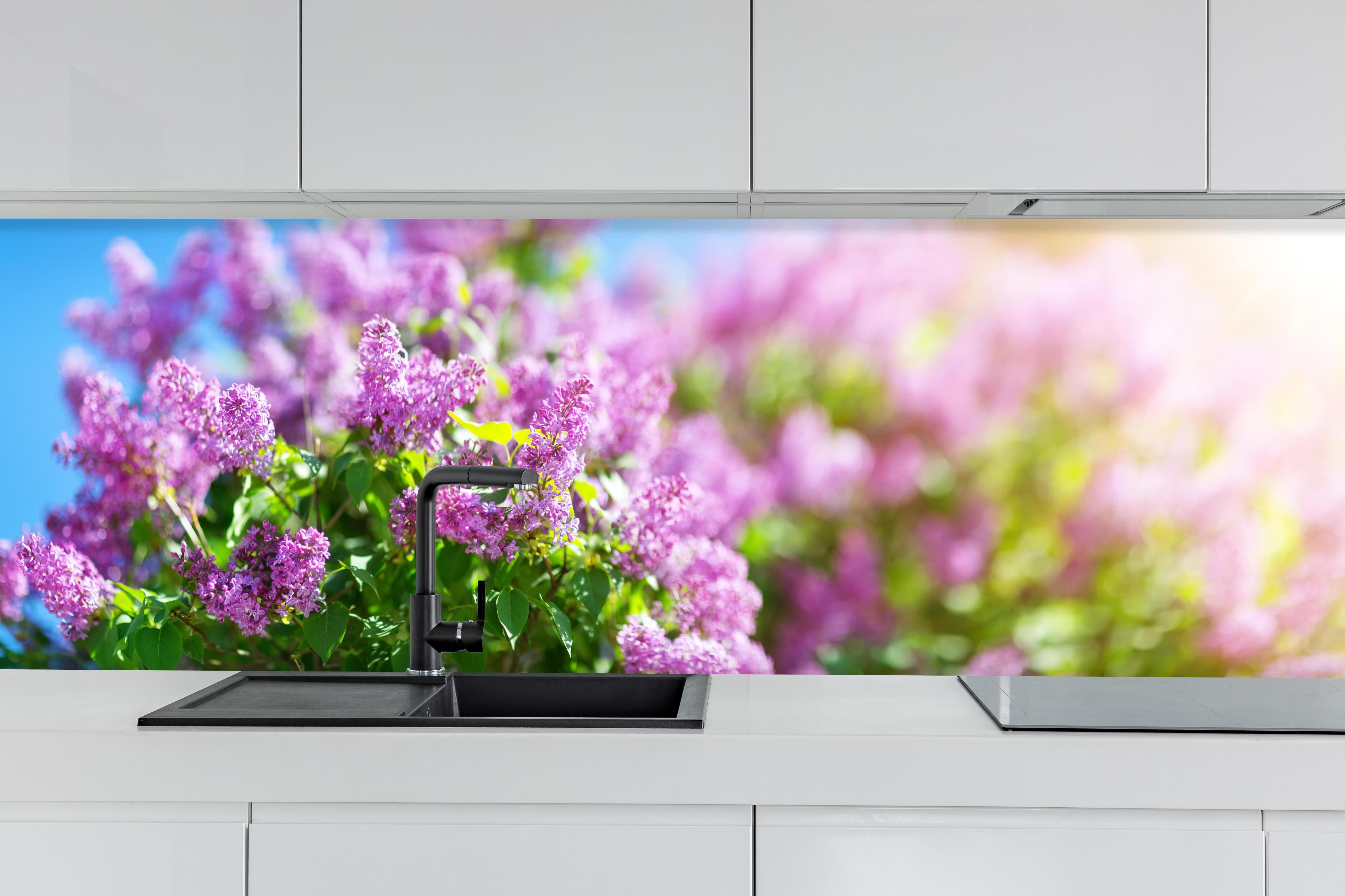 Küche - Blumen blühen auf im Frühling hinter weißen Hochglanz-Küchenregalen und schwarzem Wasserhahn