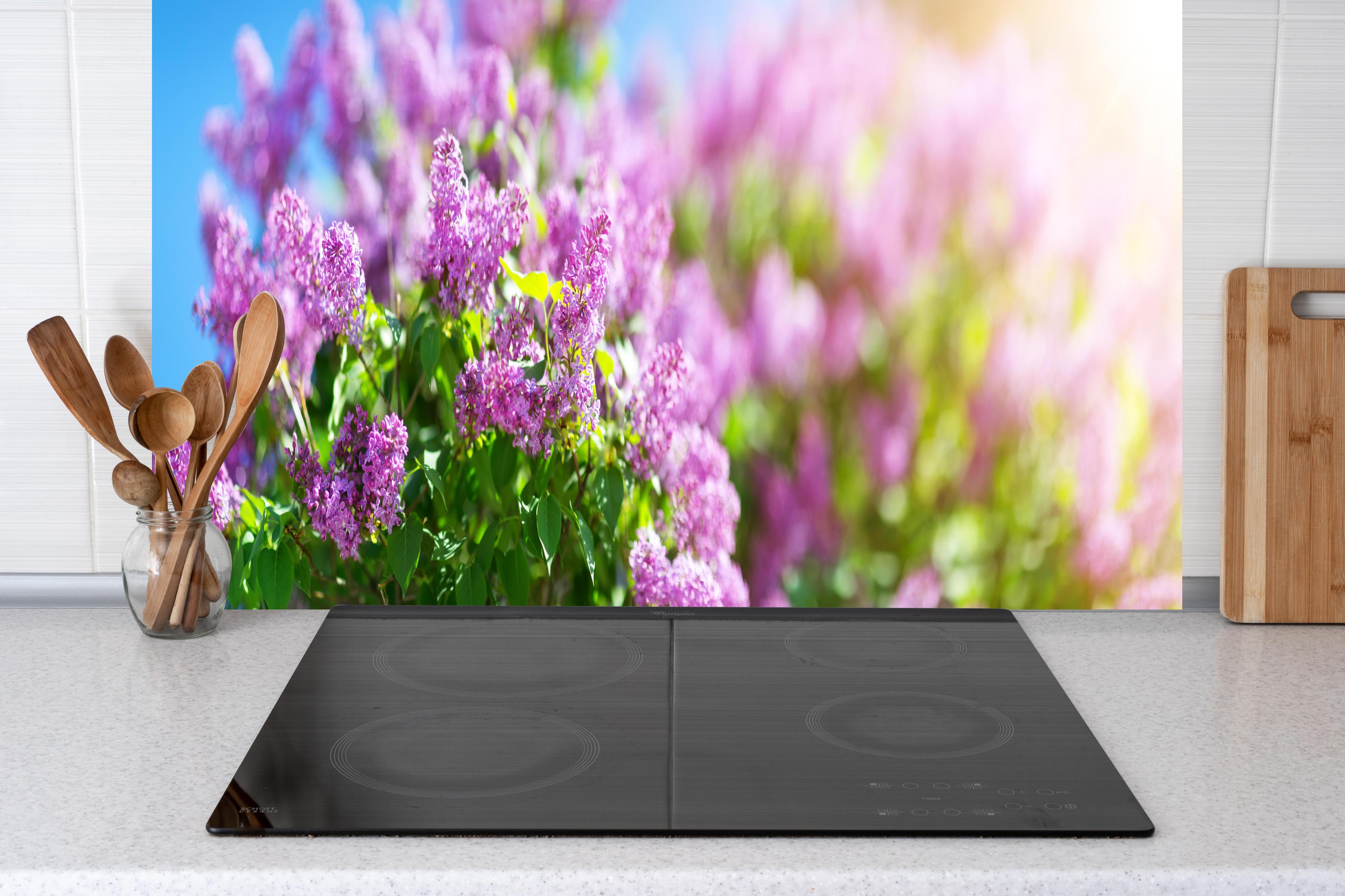 Küche - Blumen blühen auf im Frühling hinter weißen Hochglanz-Küchenregalen und schwarzem Wasserhahn