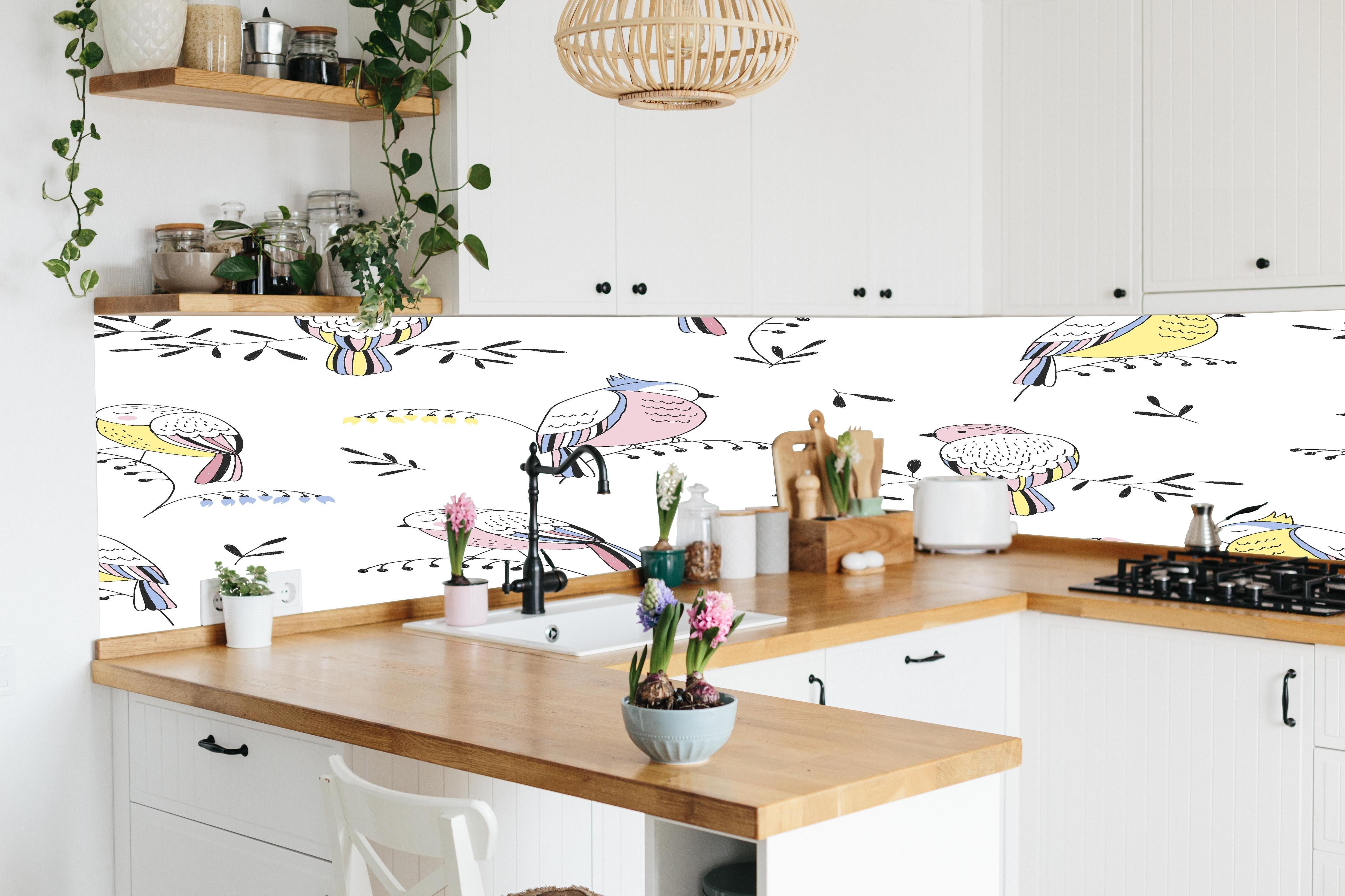 Küche - Bunte Vögel Muster Illustration hinter weißen Hochglanz-Küchenregalen und schwarzem Wasserhahn