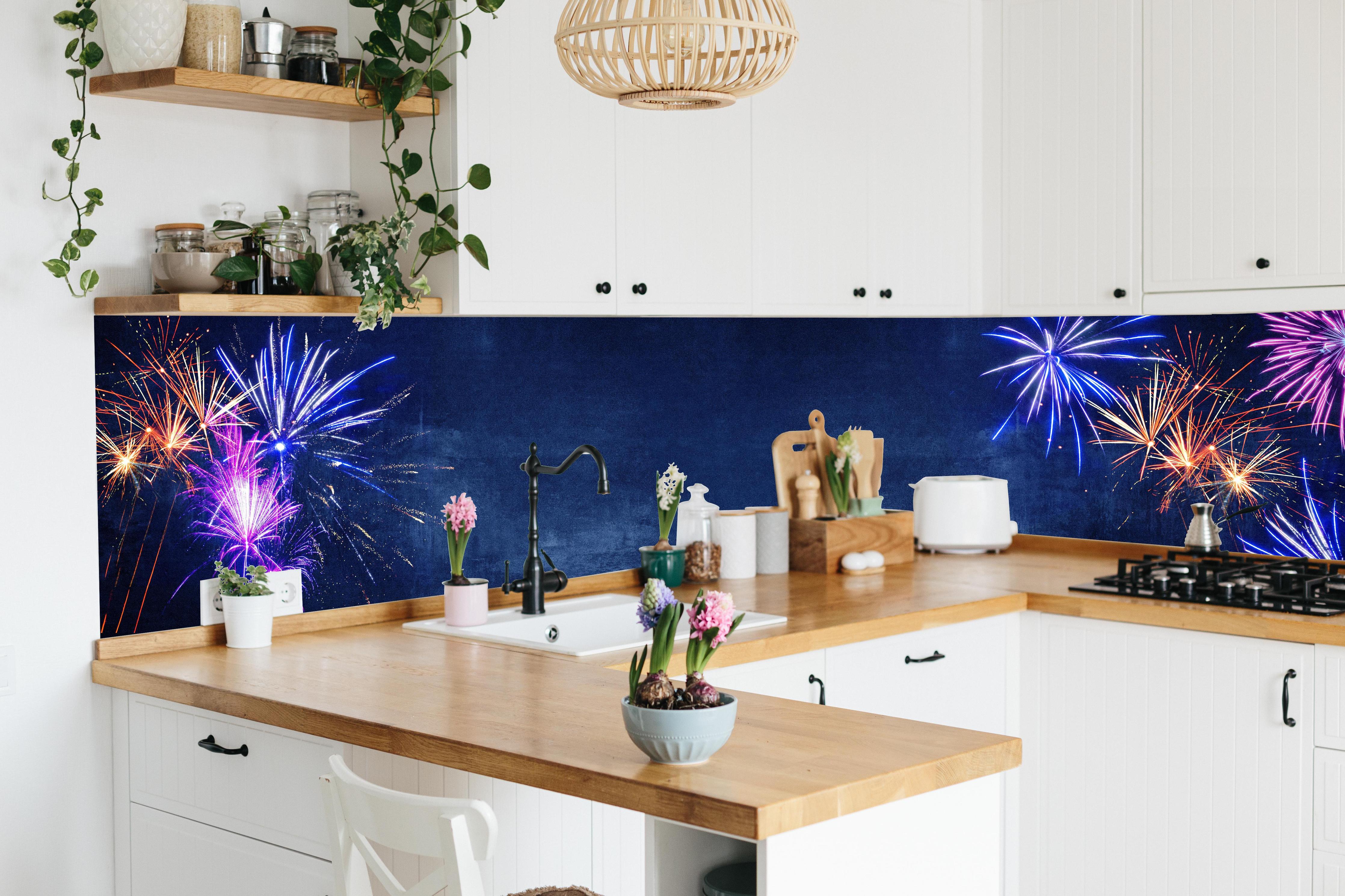 Küche - Buntes Silvester-Feuerwerk am Dunkelblauen Himmel hinter weißen Hochglanz-Küchenregalen und schwarzem Wasserhahn