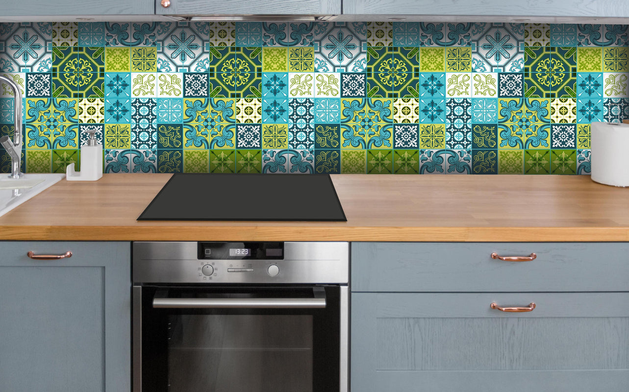 Küche - Dekorative Blau-Grüne Fliesen mit Muster hinter weißen Hochglanz-Küchenregalen und schwarzem Wasserhahn