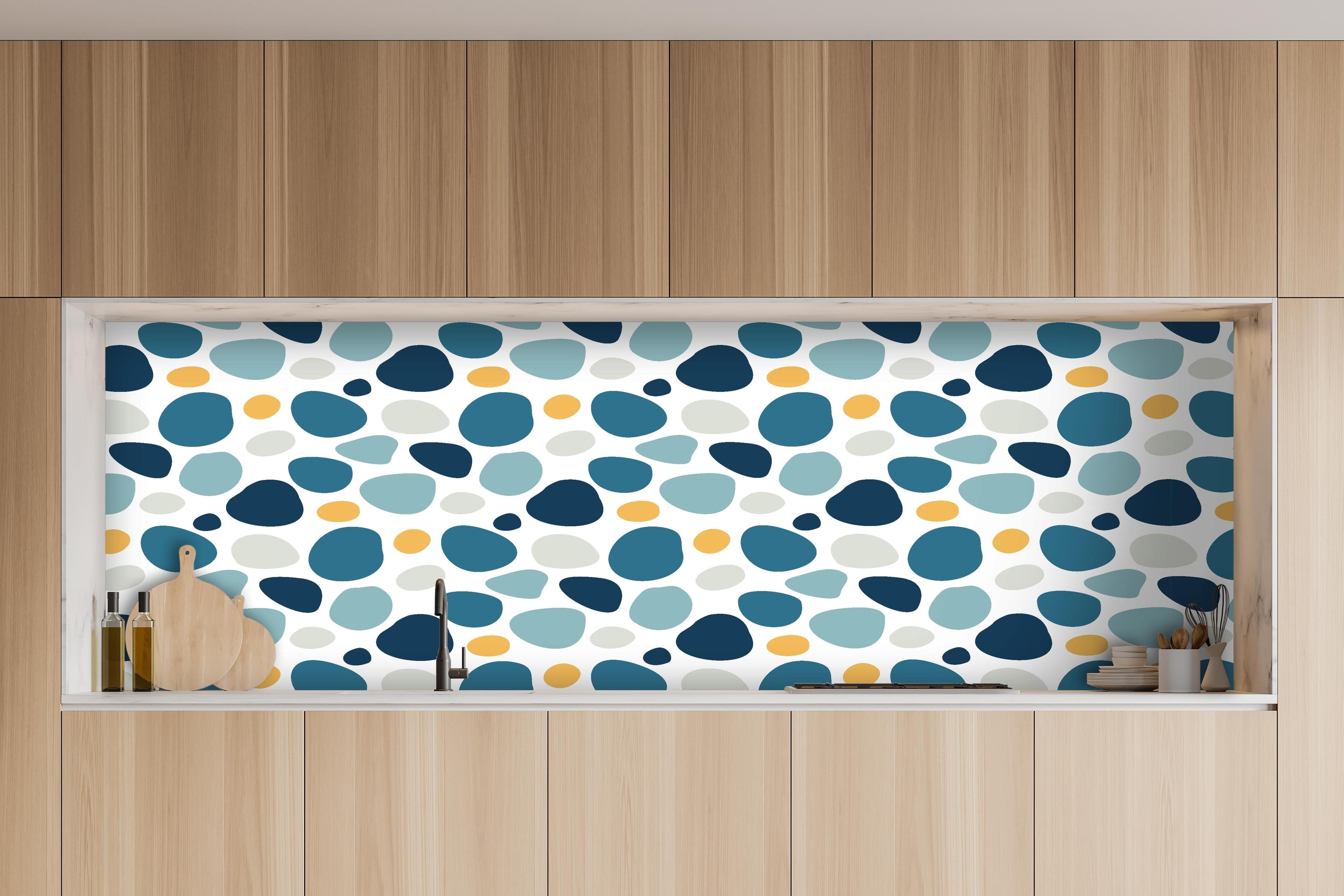 Küche - Dekoratives Blau-Weiß-Oranges Designmuster hinter weißen Hochglanz-Küchenregalen und schwarzem Wasserhahn