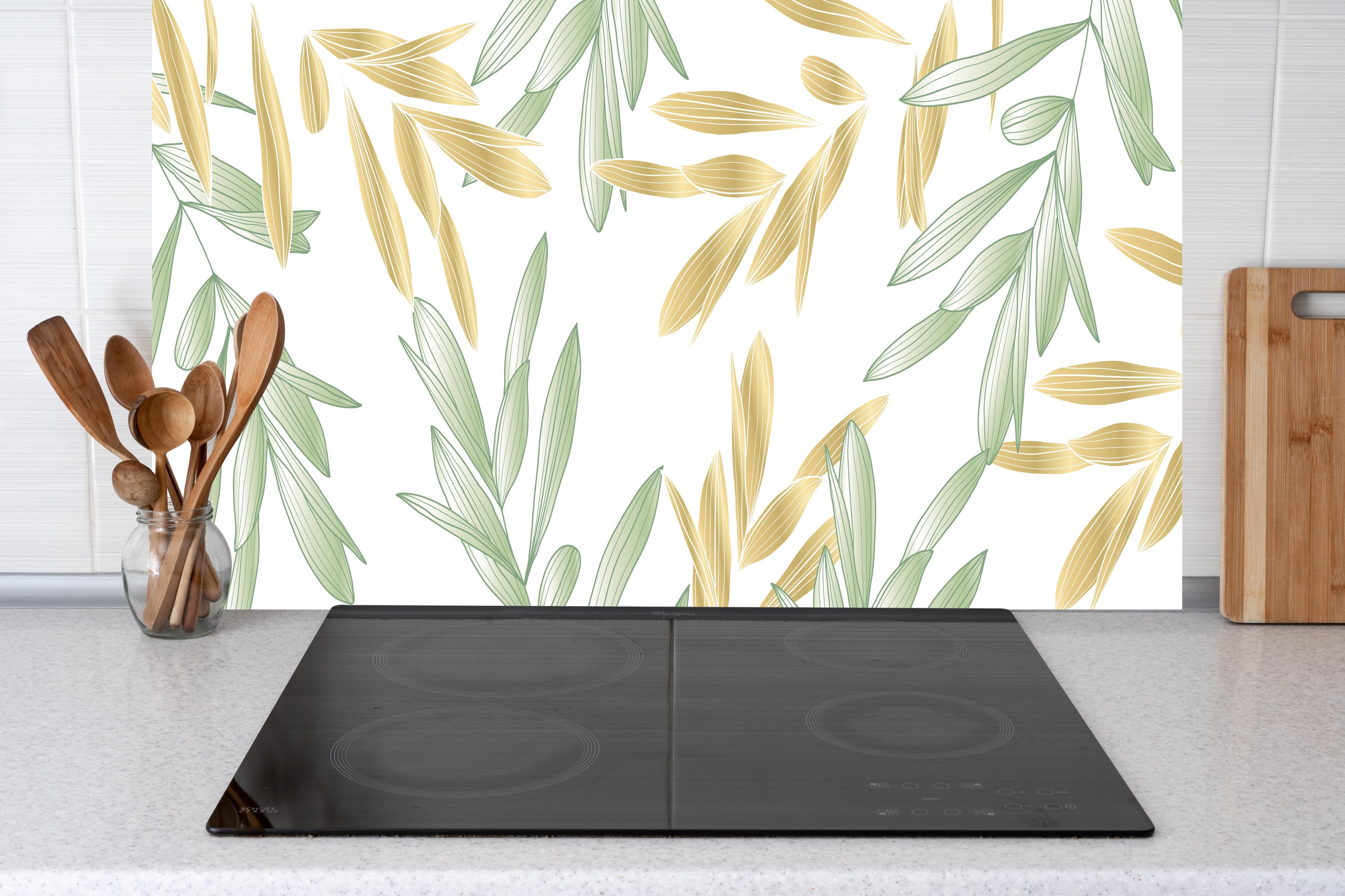 Küche - Dekoratives Grün-Gold Pflanzen-Design hinter weißen Hochglanz-Küchenregalen und schwarzem Wasserhahn