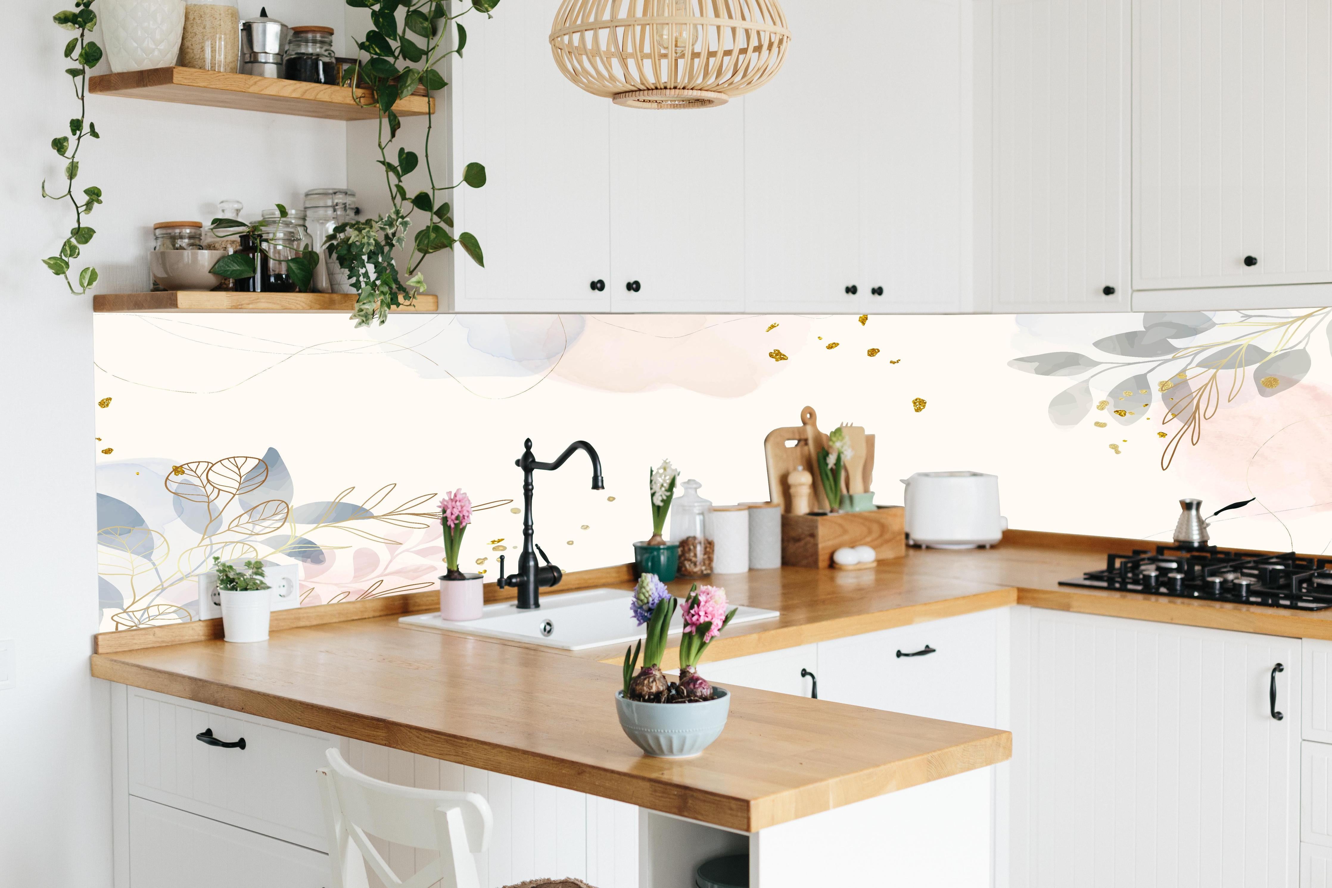 Küche - Design mit Blüten und Blättern in Pastell hinter weißen Hochglanz-Küchenregalen und schwarzem Wasserhahn