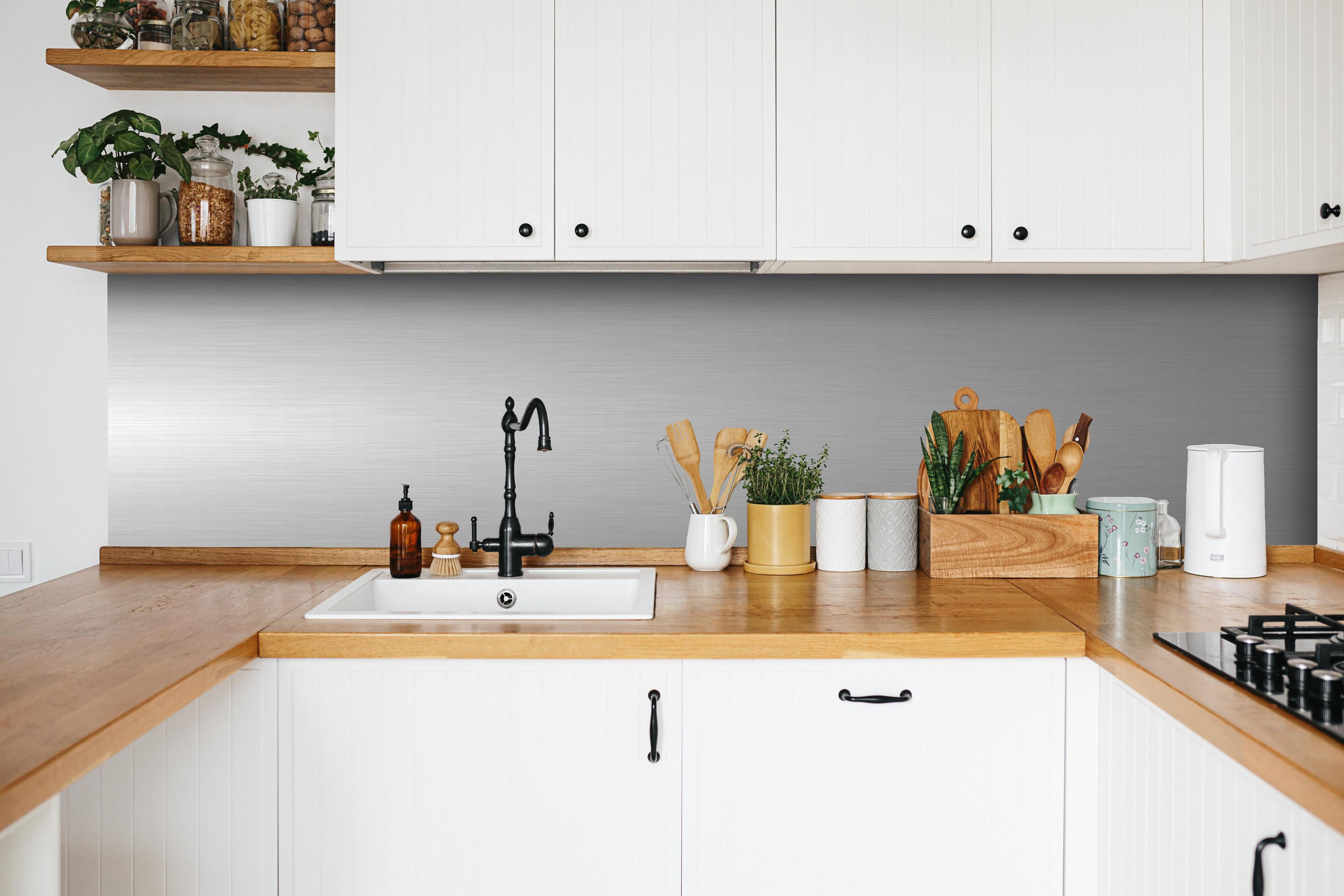 Küche - Edler gebürsteter Metall-Hintergrund in Graunuancen hinter weißen Hochglanz-Küchenregalen und schwarzem Wasserhahn