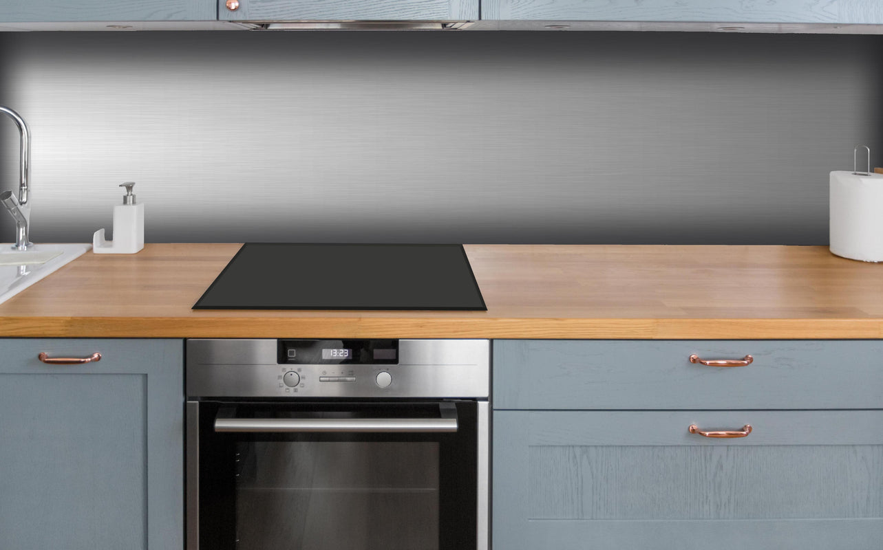 Küche - Edler gebürsteter Metall-Hintergrund in Graunuancen hinter weißen Hochglanz-Küchenregalen und schwarzem Wasserhahn