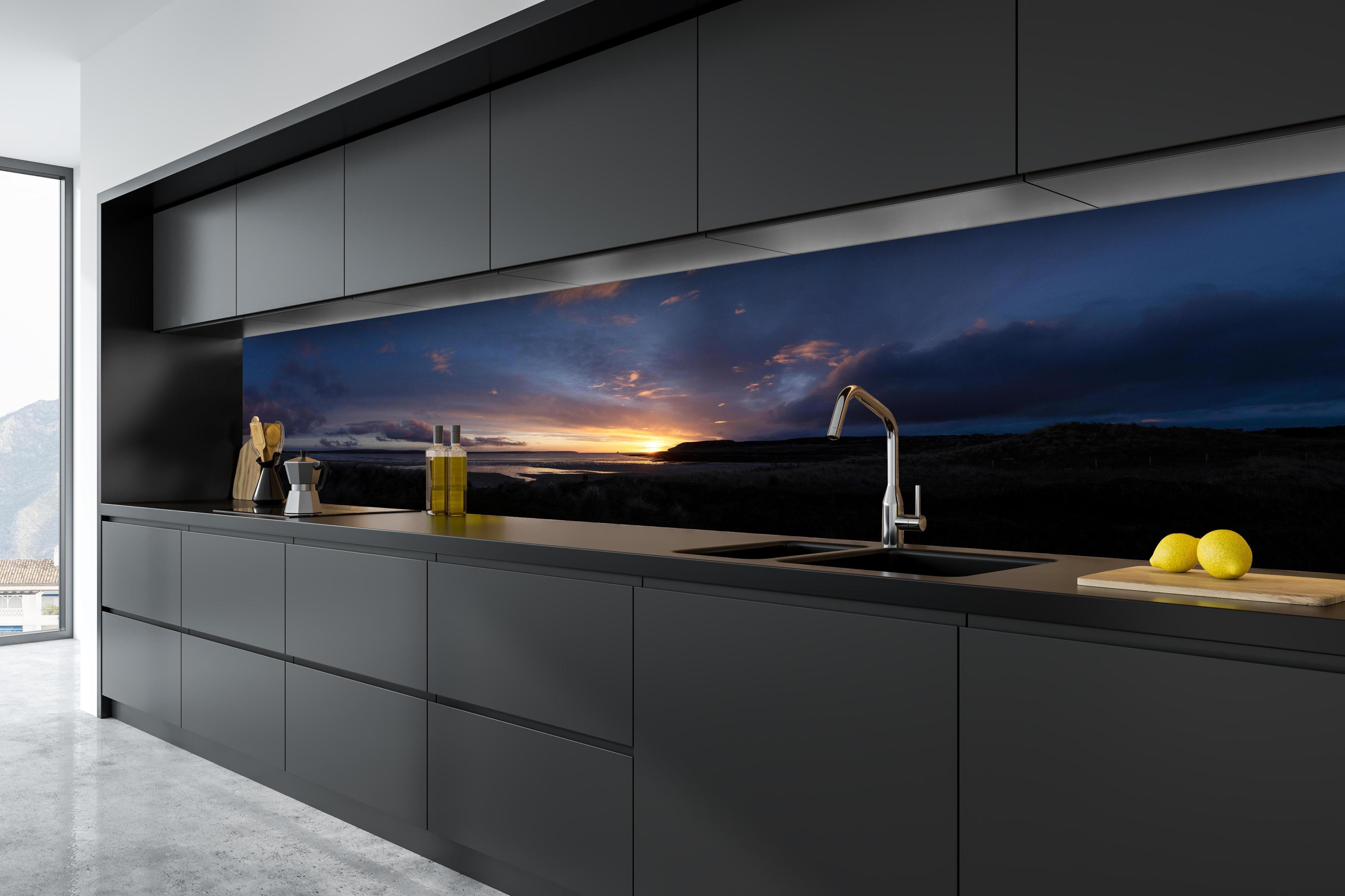 Küche - Ein malerischer Sonnenuntergang über einem ruhigen See, die Wolken leuchten in verschiedenen Blau- und Orangetönen hinter weißen Hochglanz-Küchenregalen und schwarzem Wasserhahn