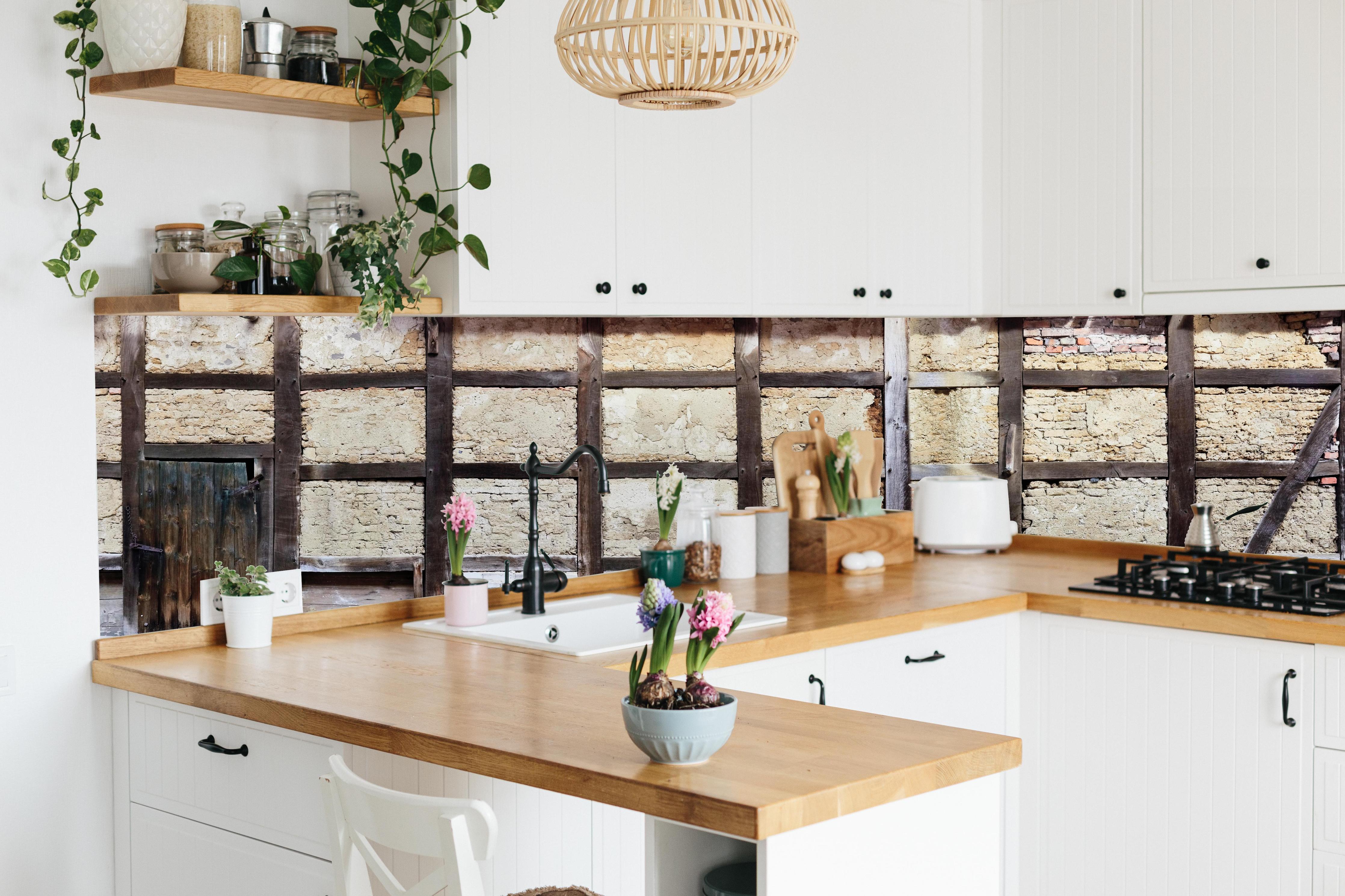 Küche - Eingang eines Deutschen Fachwerkhauses hinter weißen Hochglanz-Küchenregalen und schwarzem Wasserhahn