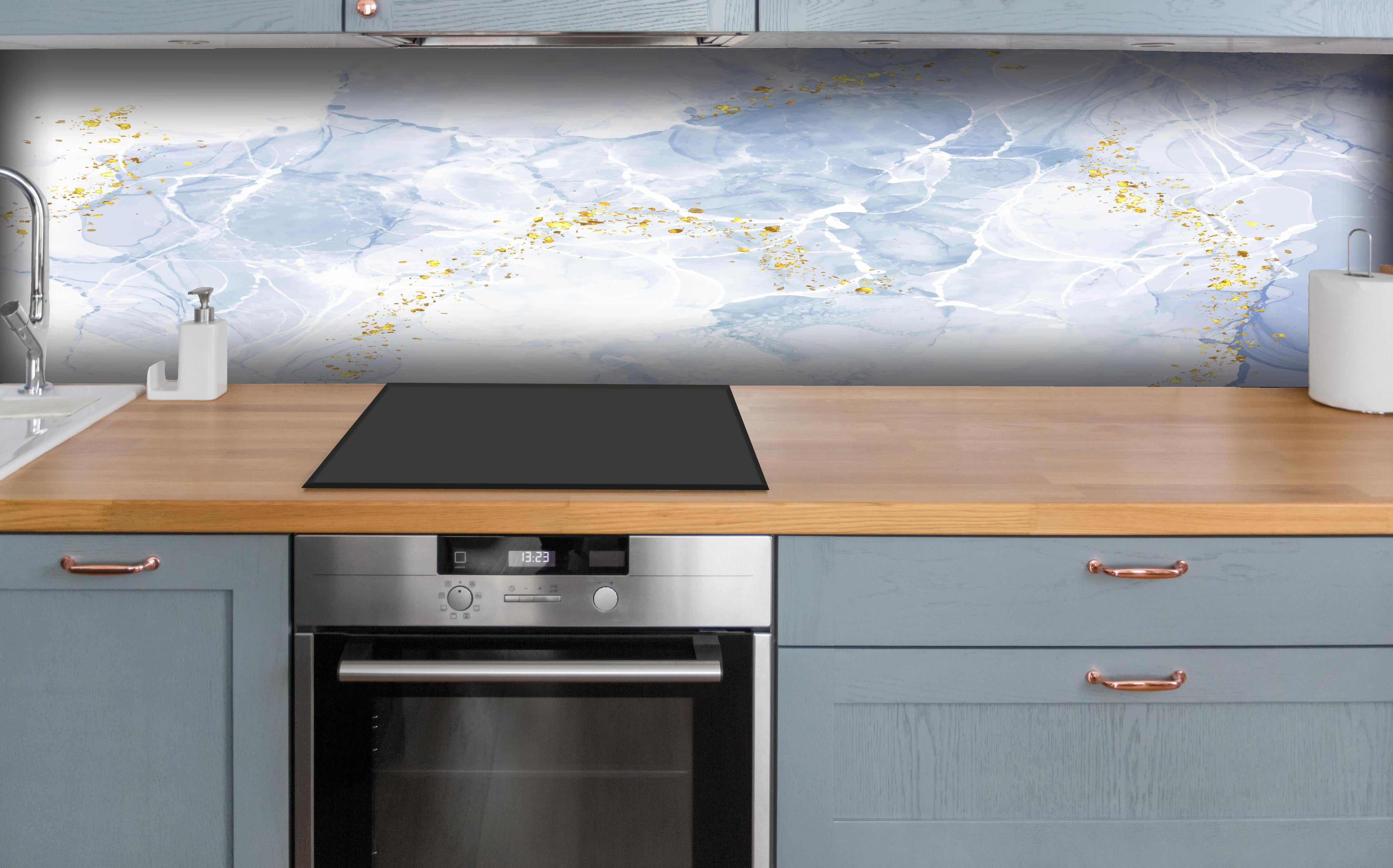 Küche - Eisiges Blau mit Goldakzenten hinter weißen Hochglanz-Küchenregalen und schwarzem Wasserhahn