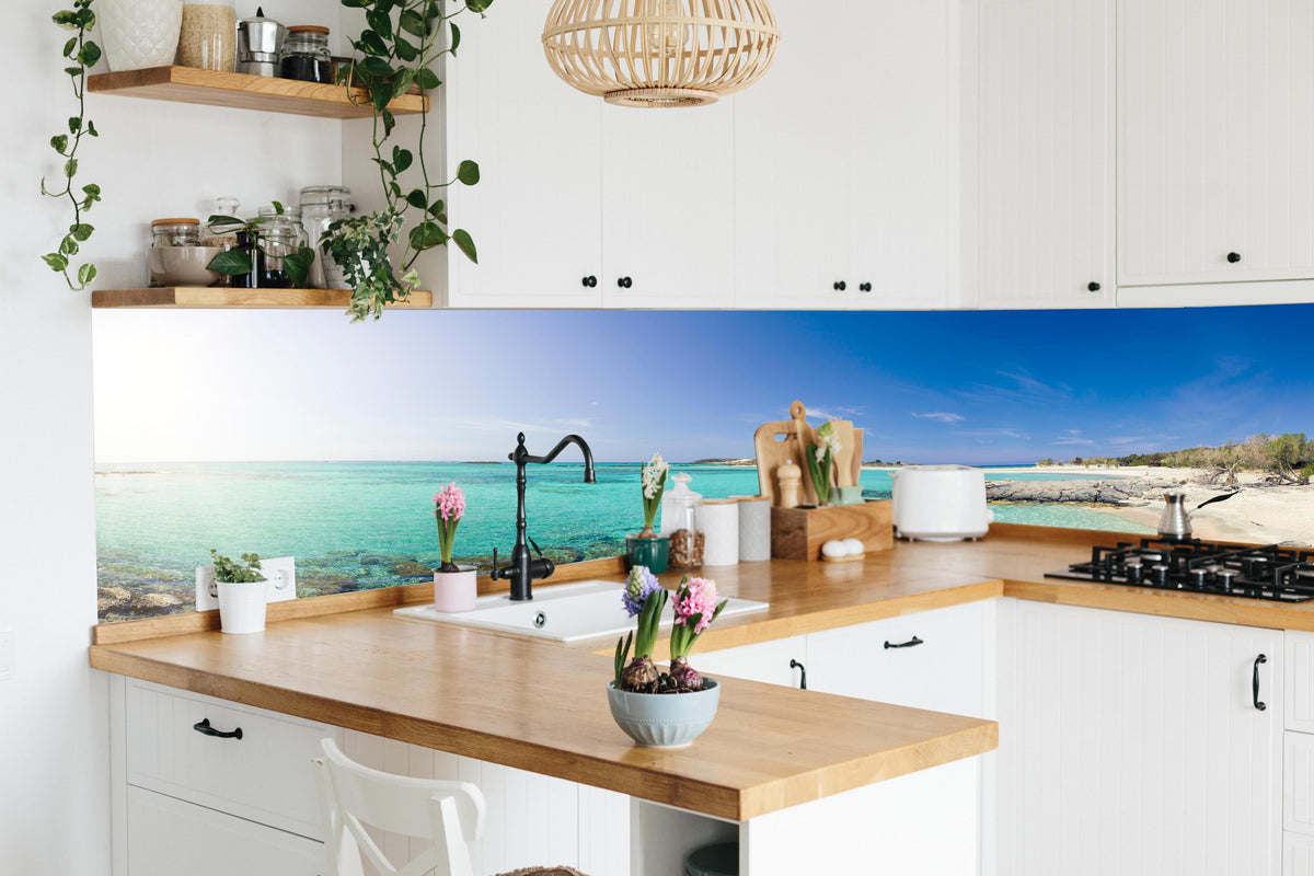 Küche - Elafonisi Strand Blaues Meer Panorama hinter weißen Hochglanz-Küchenregalen und schwarzem Wasserhahn