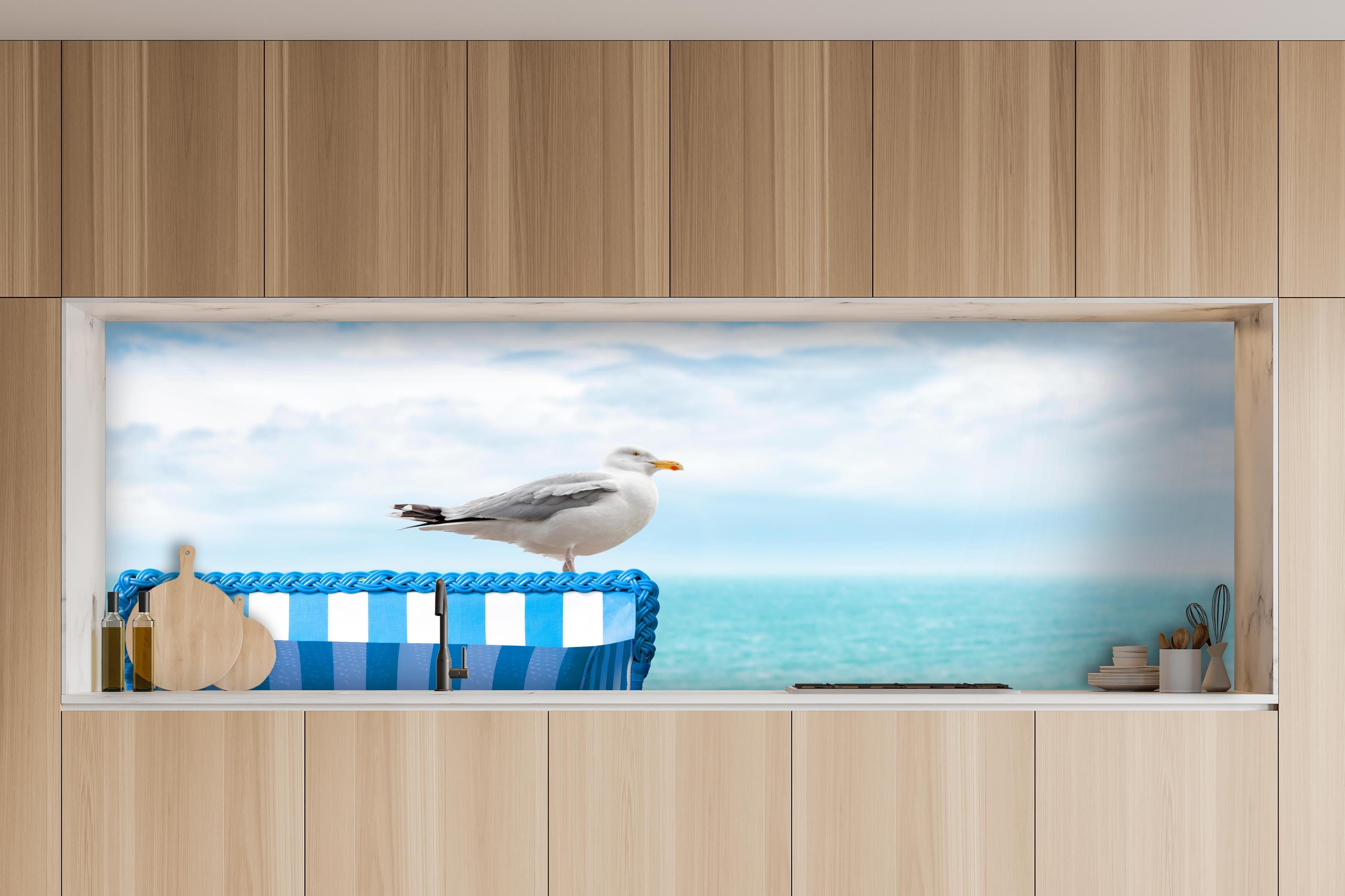 Küche - Elegant Seagull Perched on Blue Beach Chair by the Tranquil Ocean hinter weißen Hochglanz-Küchenregalen und schwarzem Wasserhahn