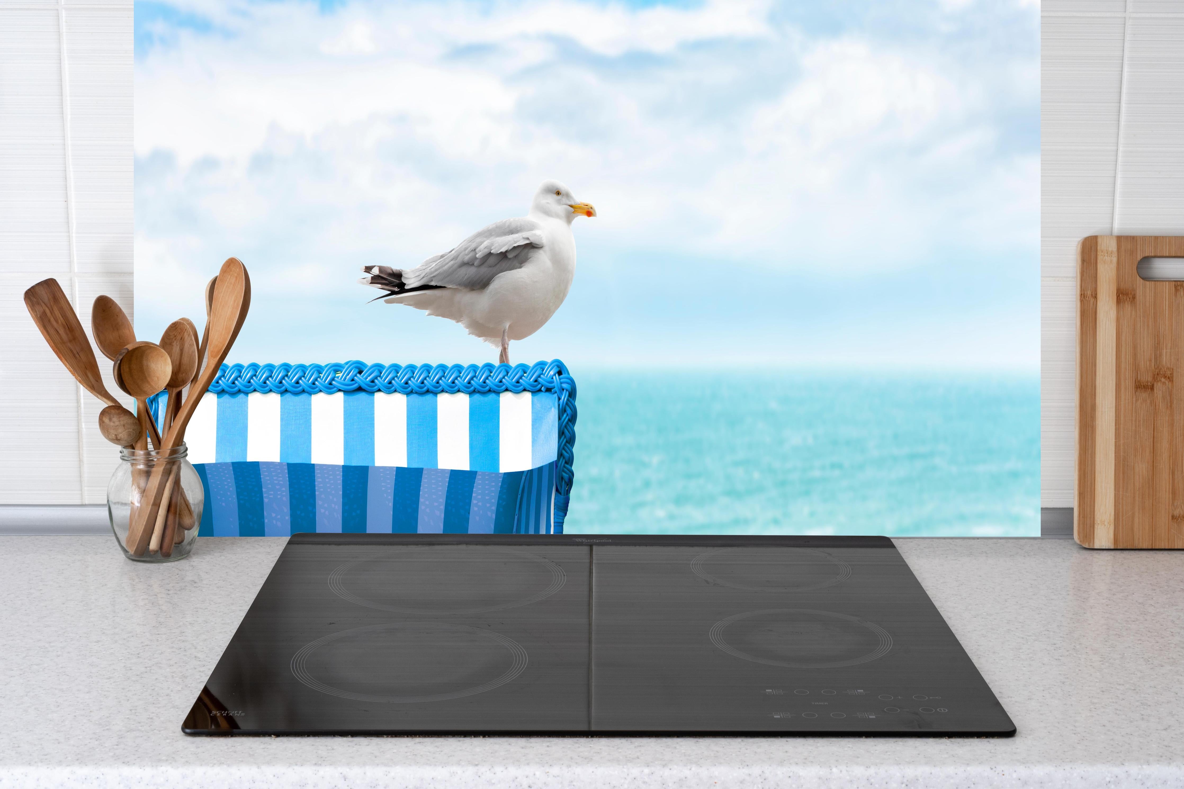 Küche - Elegant Seagull Perched on Blue Beach Chair by the Tranquil Ocean hinter weißen Hochglanz-Küchenregalen und schwarzem Wasserhahn