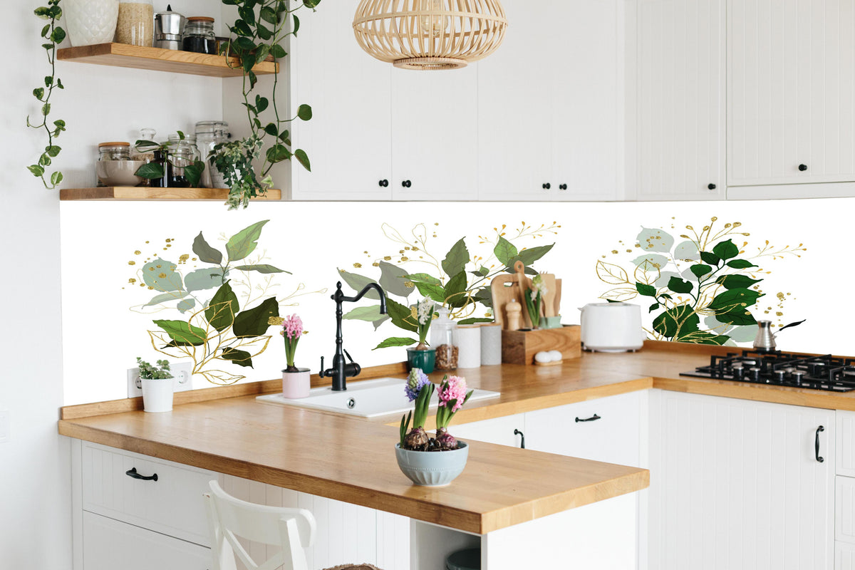 Küche - Elegante Pflanzenillustrationen in Goldtönen hinter weißen Hochglanz-Küchenregalen und schwarzem Wasserhahn