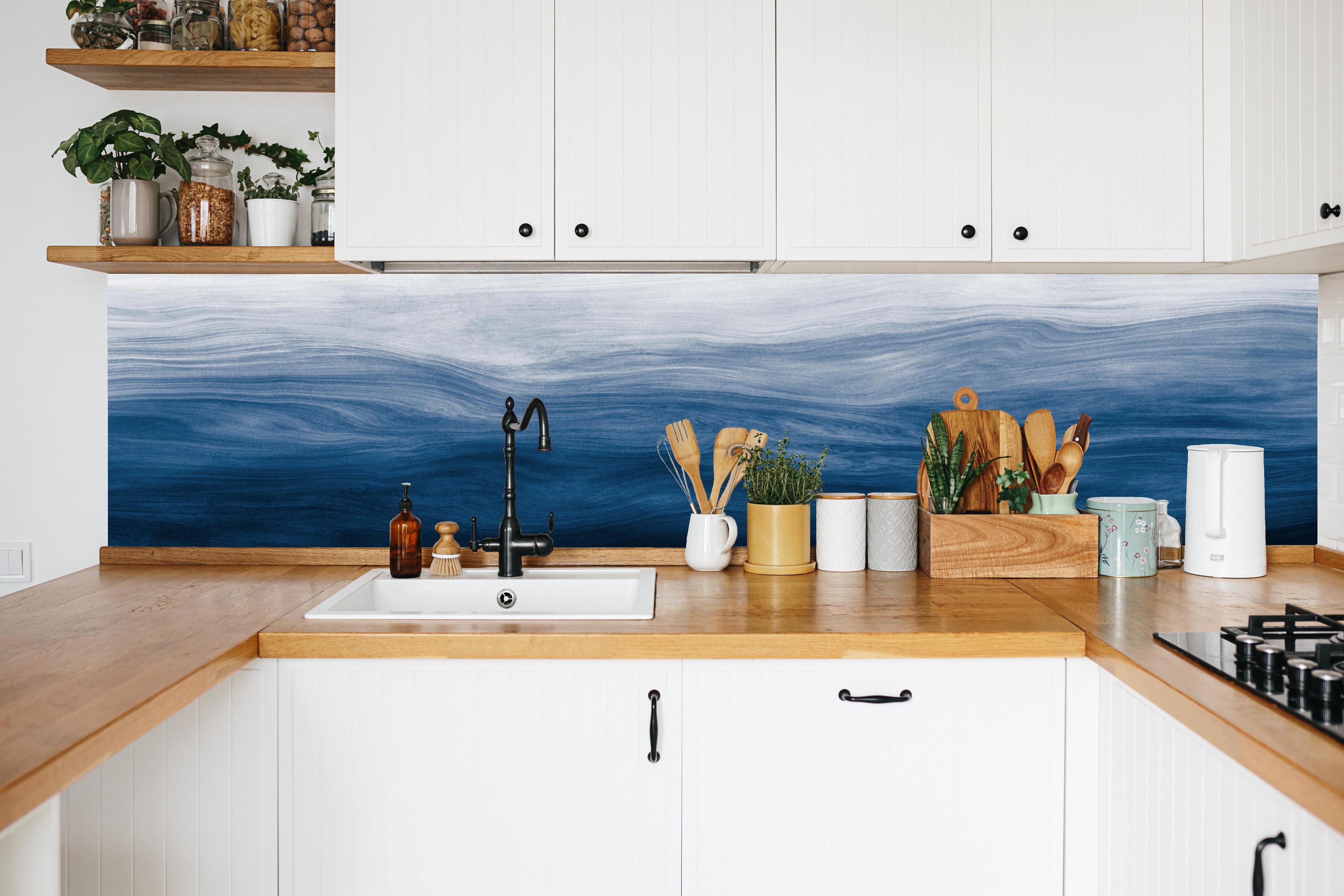 Küche - Elegante abstrakte Wellenstruktur in verschiedenen Blautönen mit Farbverlauf hinter weißen Hochglanz-Küchenregalen und schwarzem Wasserhahn