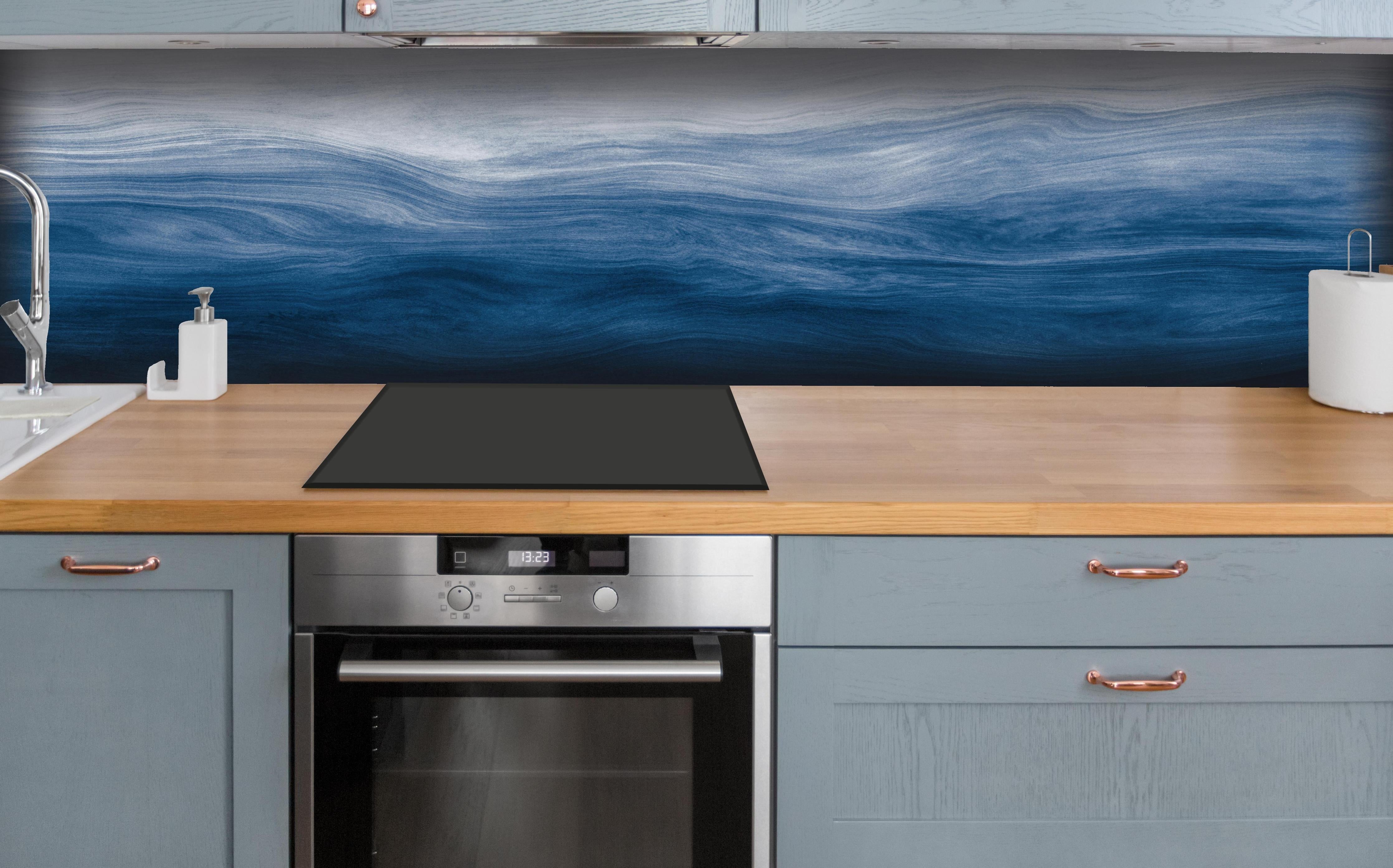 Küche - Elegante abstrakte Wellenstruktur in verschiedenen Blautönen mit Farbverlauf hinter weißen Hochglanz-Küchenregalen und schwarzem Wasserhahn