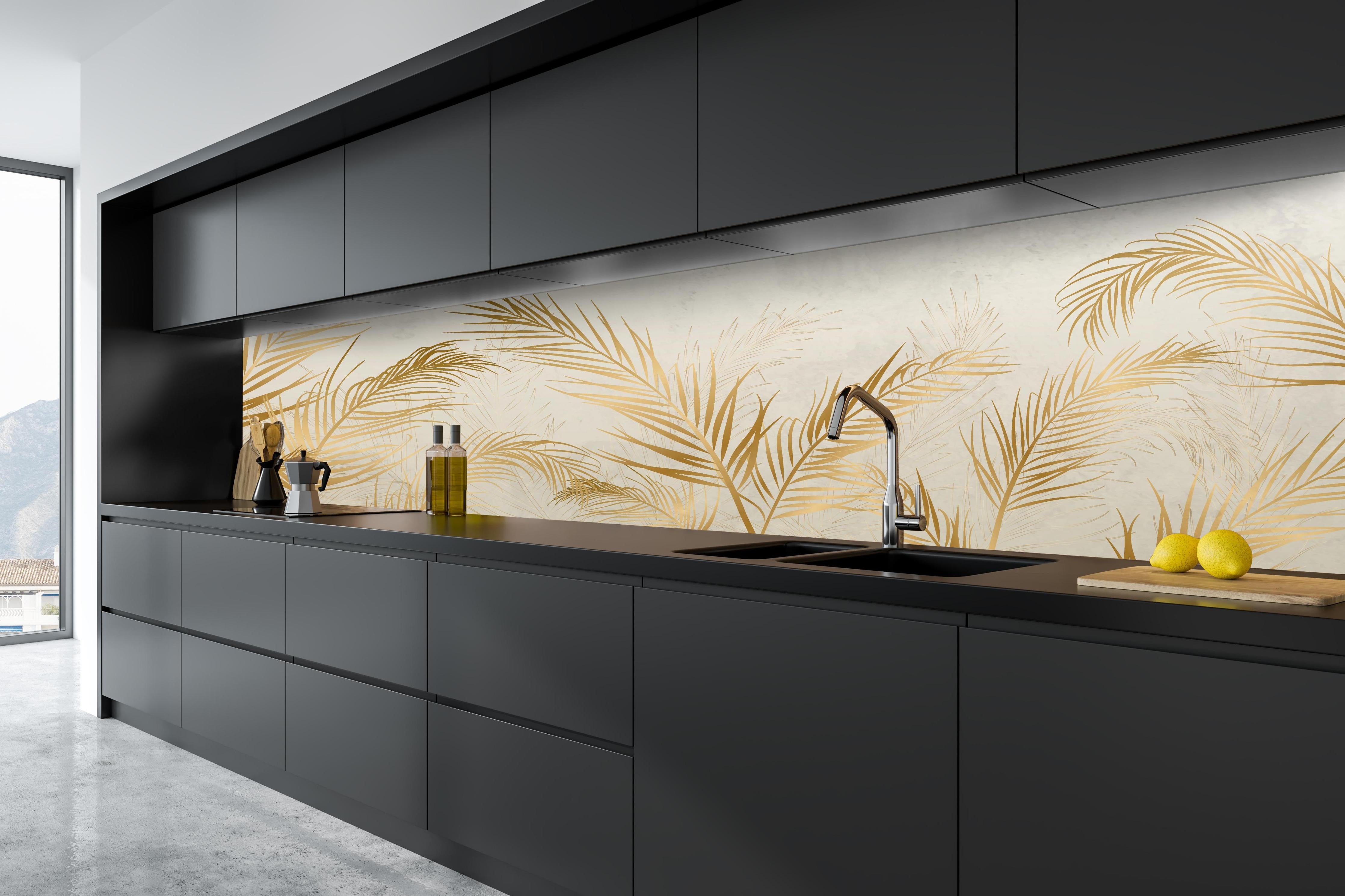 Küche - Elegante goldene Palmwedel auf hellem Grund hinter weißen Hochglanz-Küchenregalen und schwarzem Wasserhahn