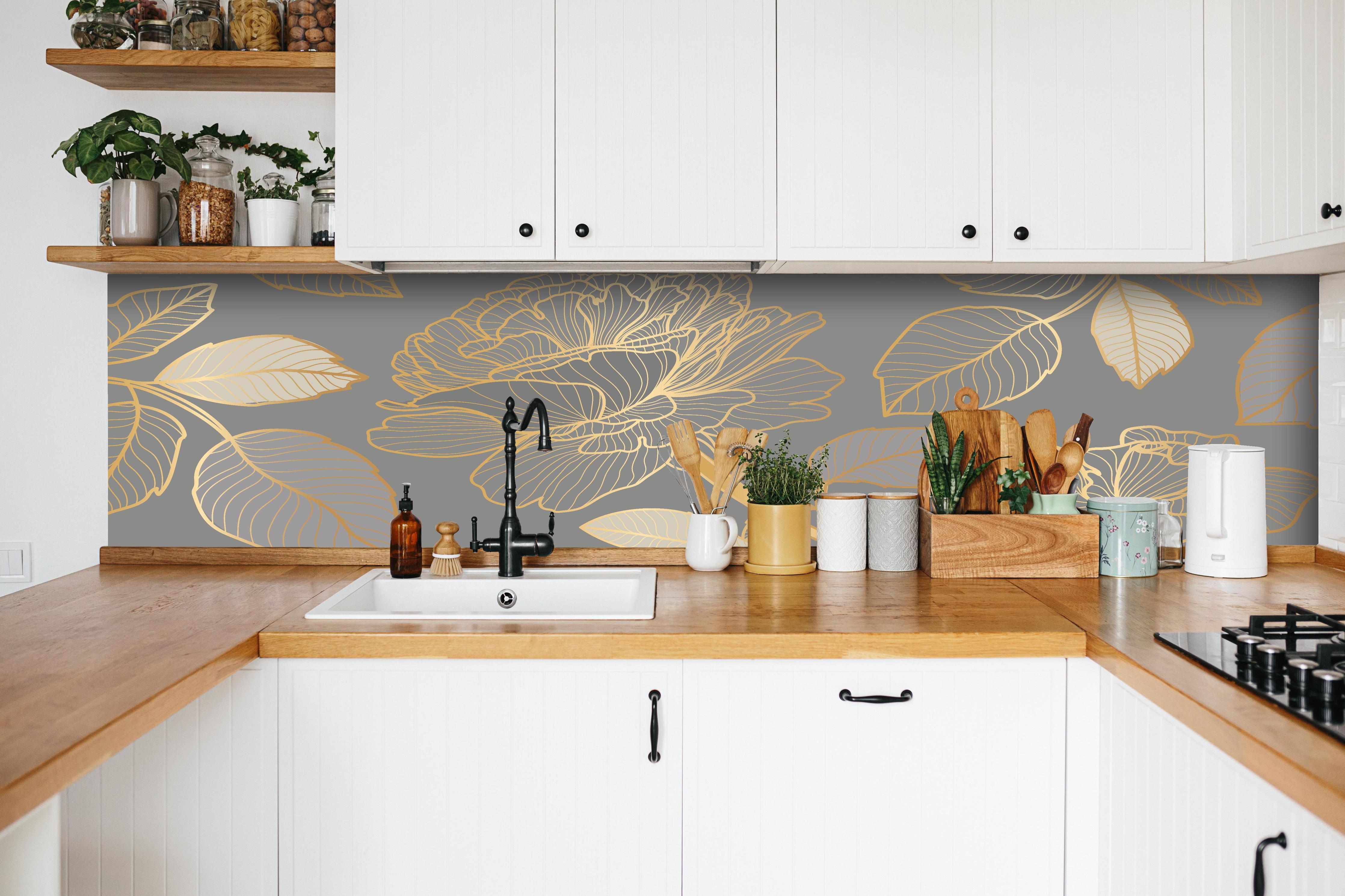 Küche - Elegantes Blumenmuster in Gold und Grau hinter weißen Hochglanz-Küchenregalen und schwarzem Wasserhahn