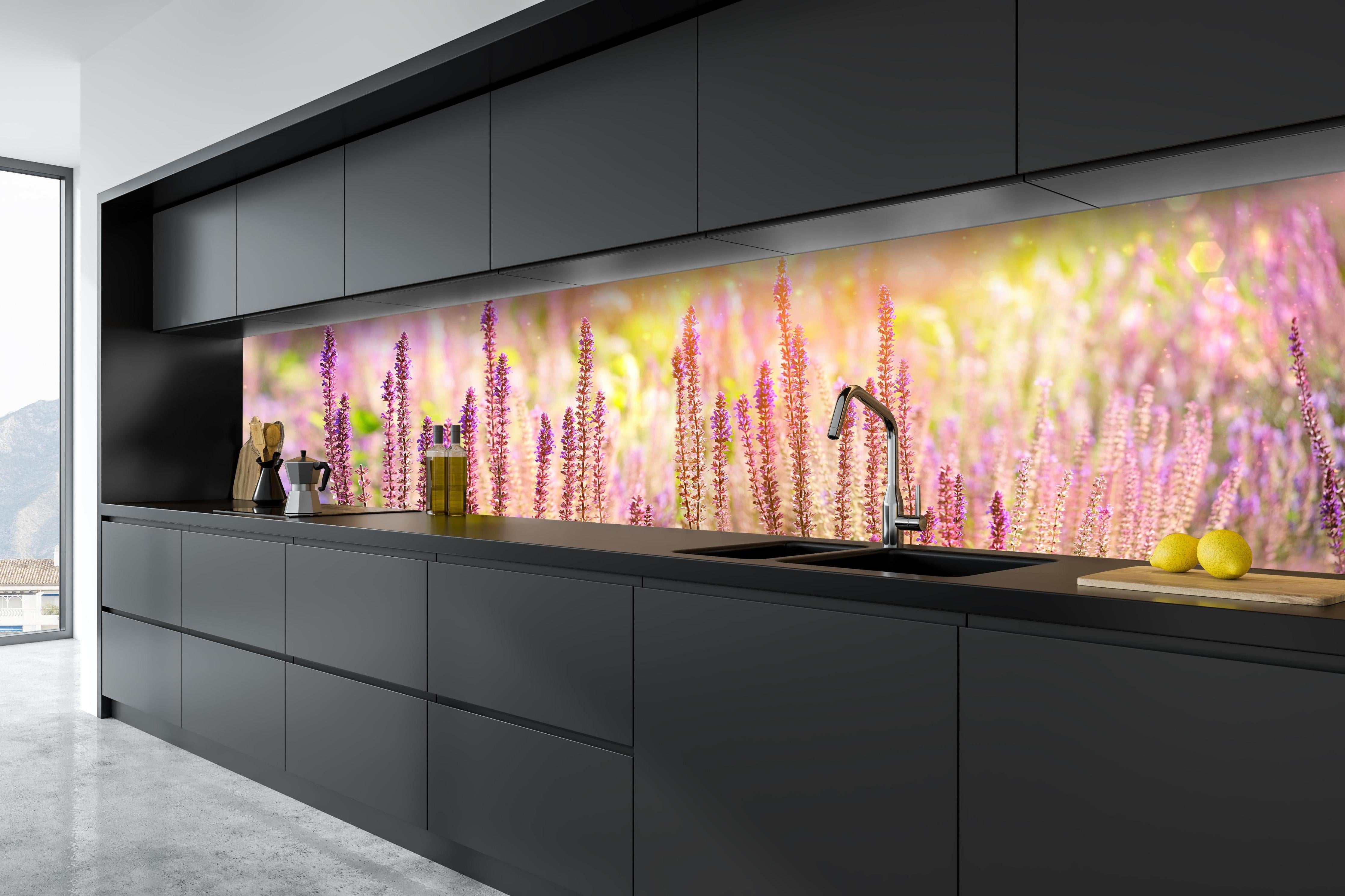 Küche - Farbenfrohe Blüten der Ziersalbei-Pflanzen hinter weißen Hochglanz-Küchenregalen und schwarzem Wasserhahn